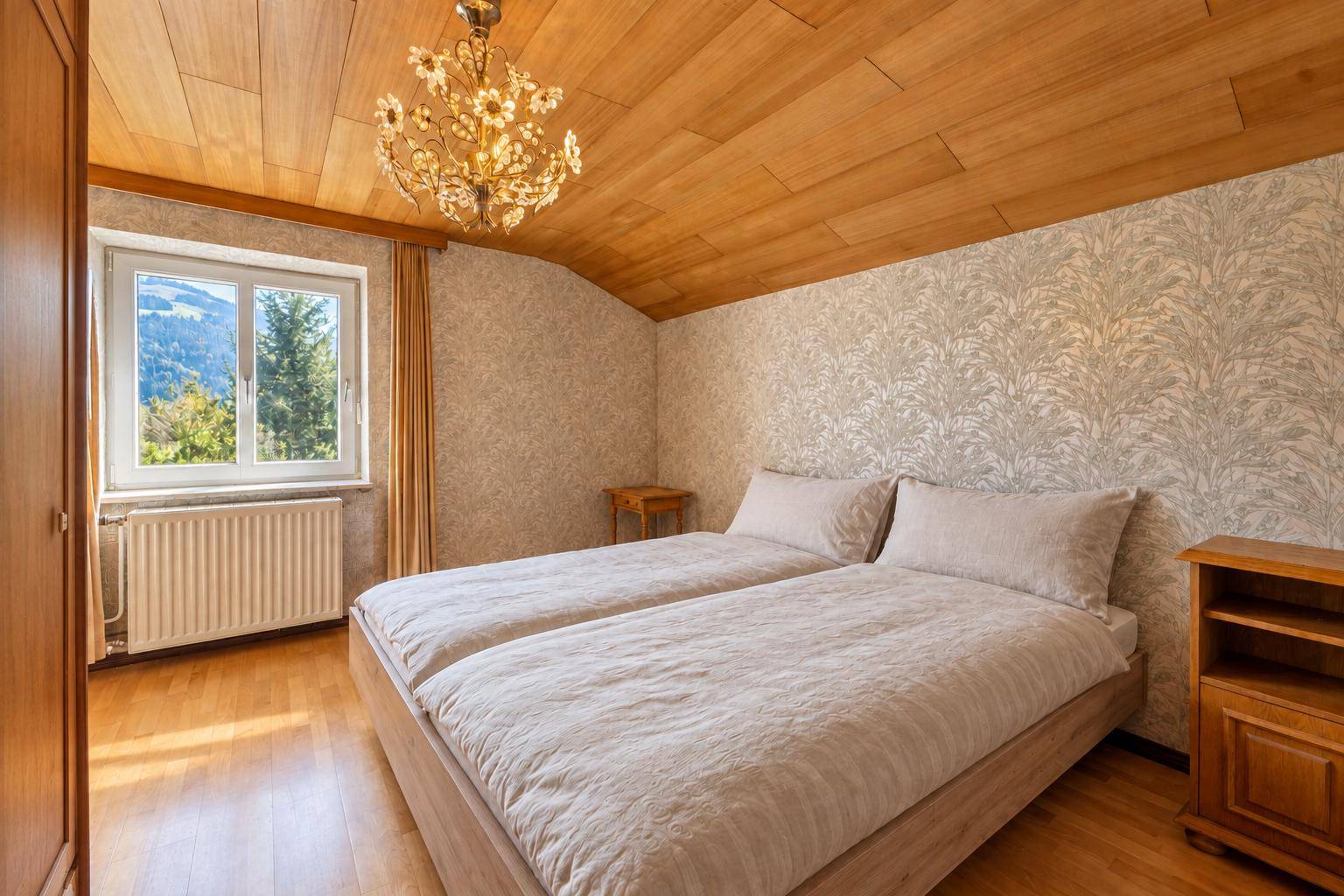Schlafzimmer mit Holzboden, Holzdecke und Fenster mit Bergblick.