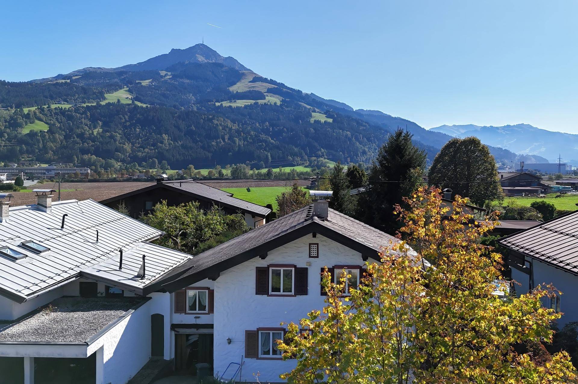 Hausfassade mit traditioneller Architektur und weitem Blick auf die umliegende Berglandschaft.