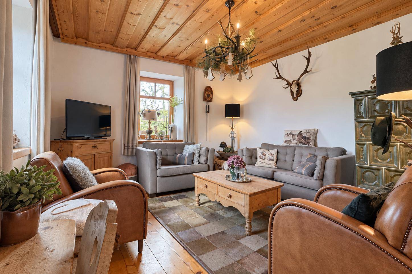 Helles Wohnzimmer mit Holzbalkendecke, traditionellen Möbeln und alpiner Dekoration.