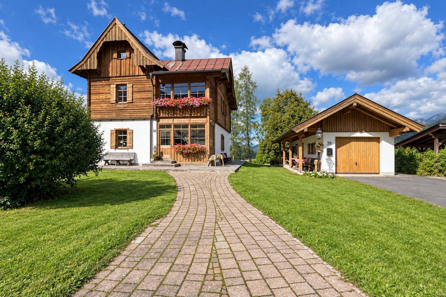 Charmantes Holzhaus mit gepflastertem Weg und separater Garage in ländlicher Umgebung.