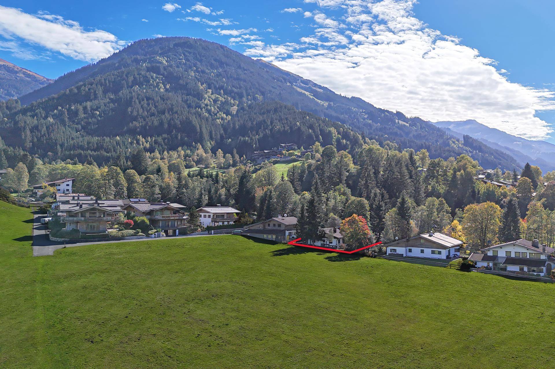 Luftaufnahme des Anwesens mit weitläufigen Grünflächen und umliegender Berglandschaft.