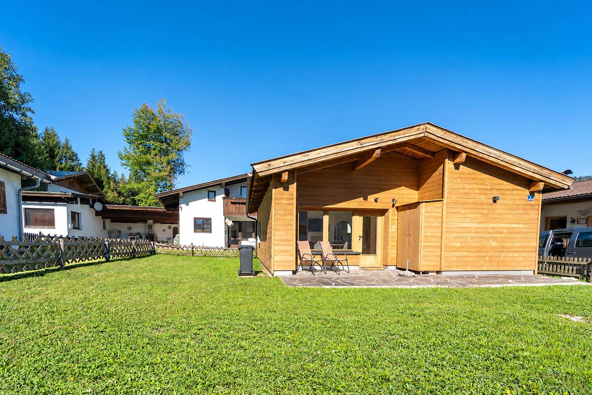 Charmantes Holzhaus mit großer Rasenfläche und umgeben von Natur.