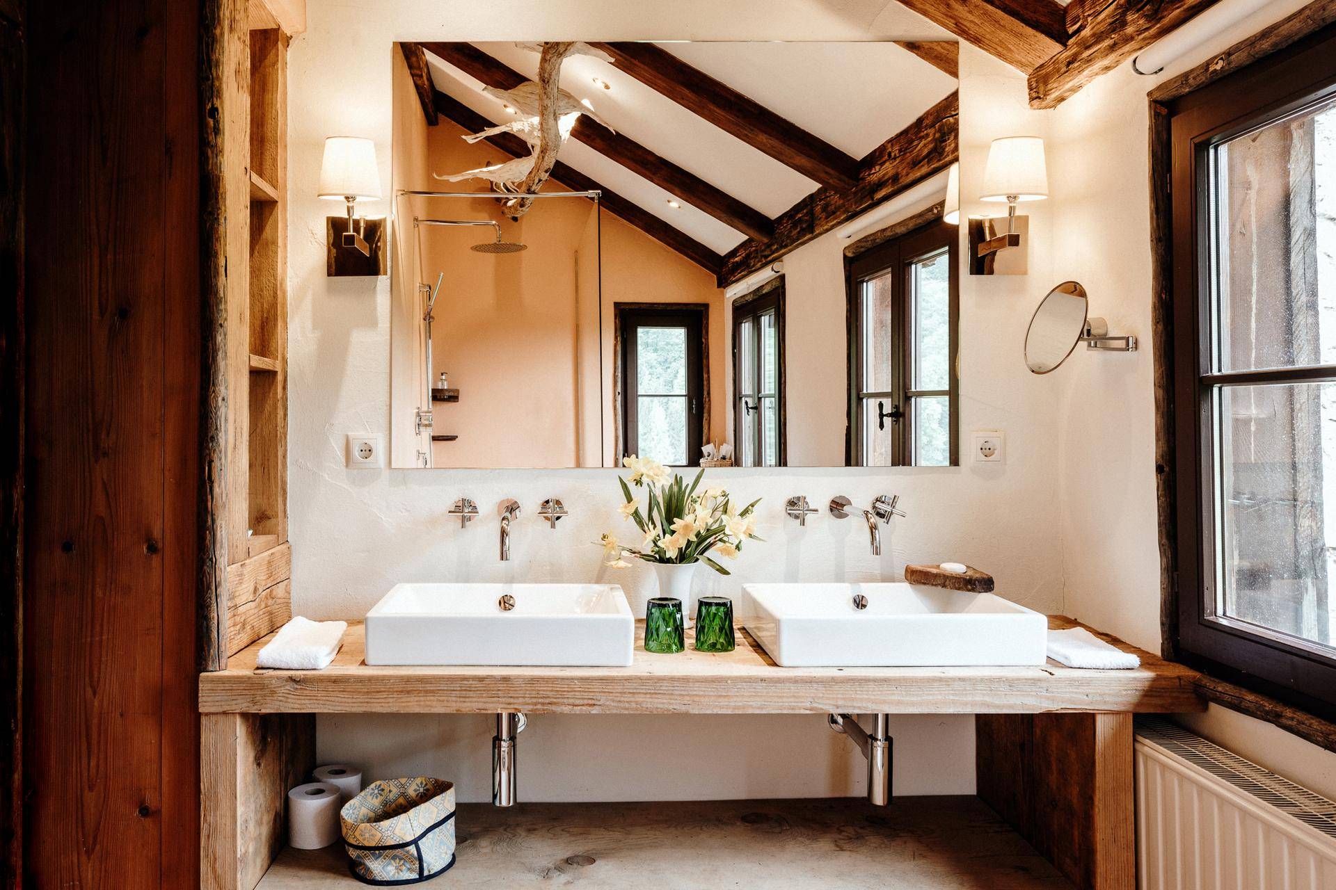 Modernes Badezimmer mit Doppelwaschbecken, Holzelementen und großer Spiegelfläche.