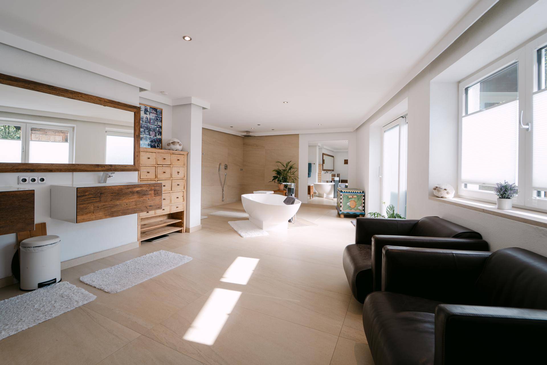 Großzügiges Badezimmer mit freistehender Badewanne, Doppelwaschbecken und viel Tageslicht.