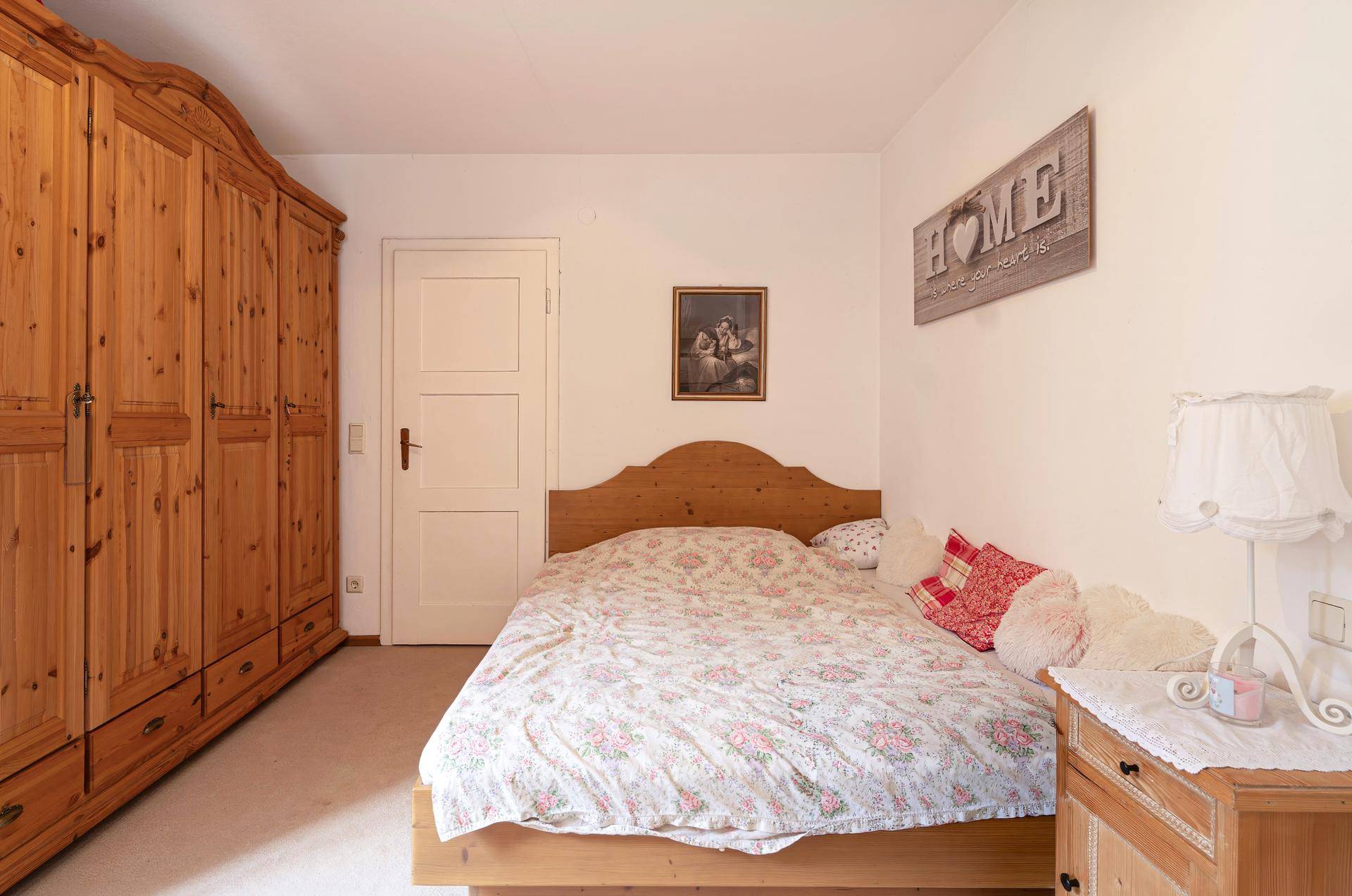 Gemütliches Schlafzimmer mit großem Holzschrank und traditionellem Bettgestell.
