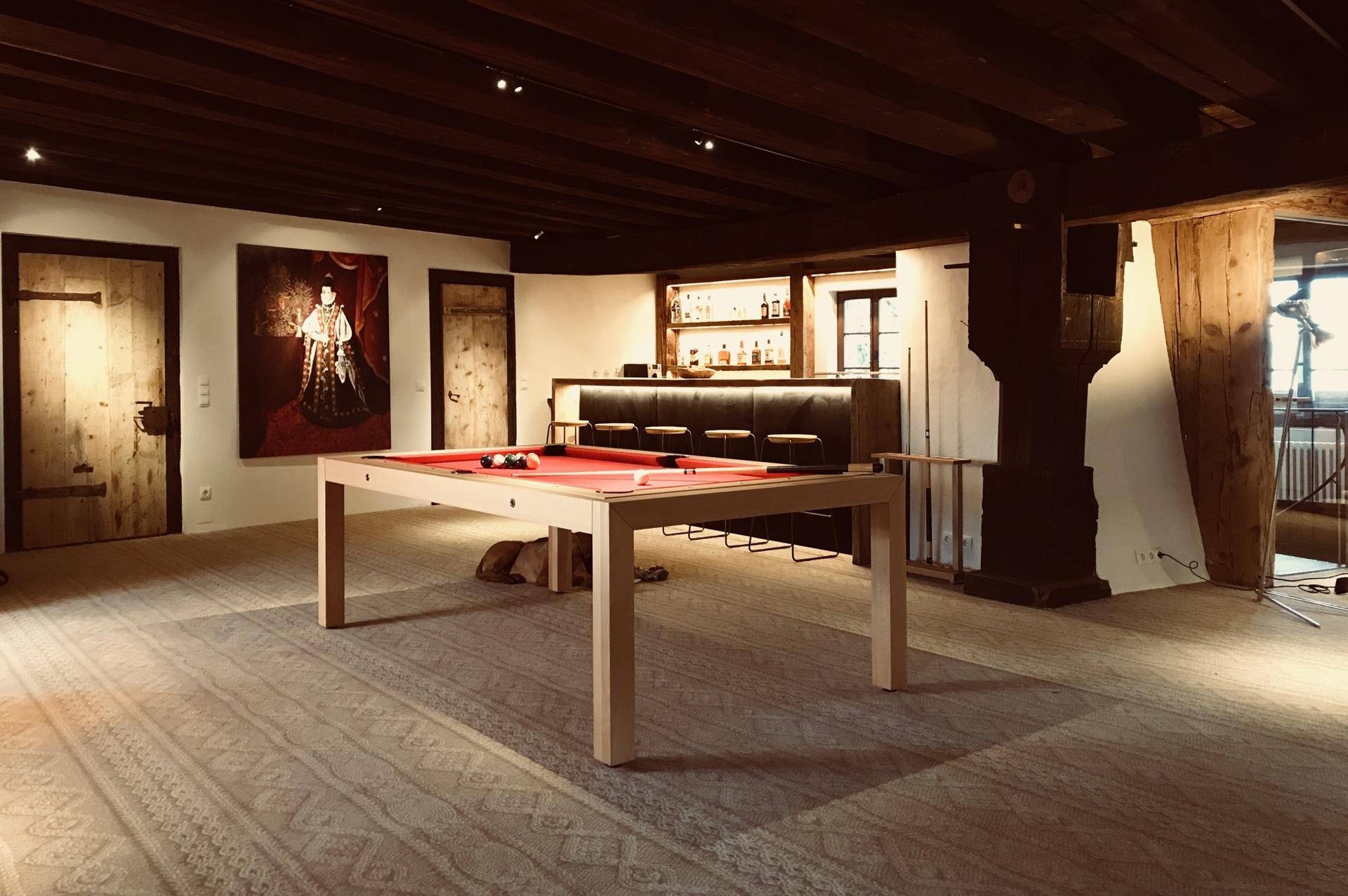 Geräumiger Spielraum mit Billardtisch, Bar und Holzbalkendecke für Unterhaltung.
