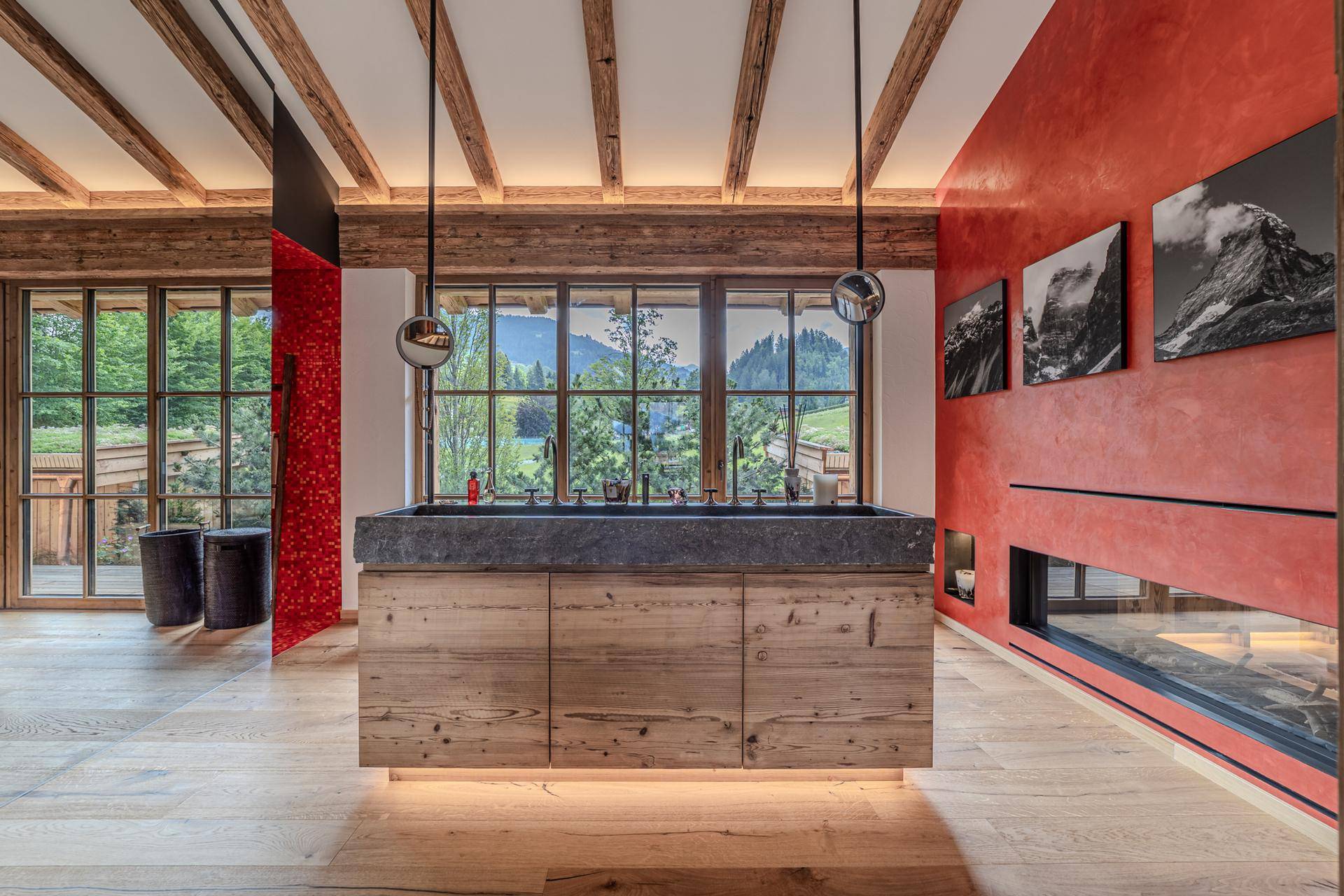 Modernes Badezimmer mit Doppelwaschbecken aus Stein, Holzelementen und integriertem Kamin.
