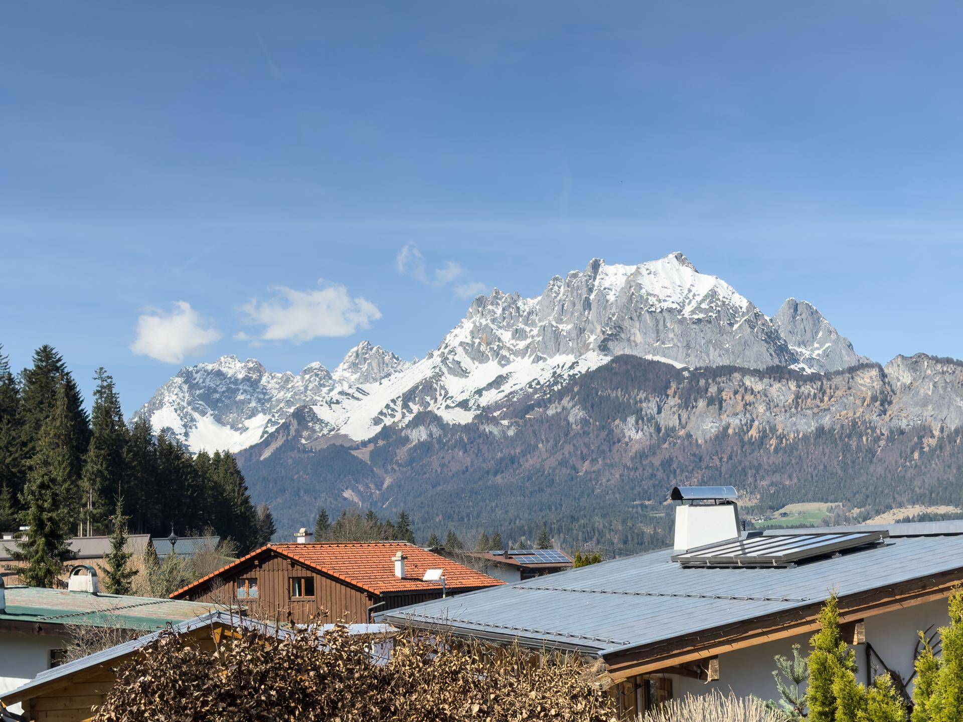 Panoramablick auf die majestätischen schneebedeckten Berge über den Dächern der umliegenden Häuser.