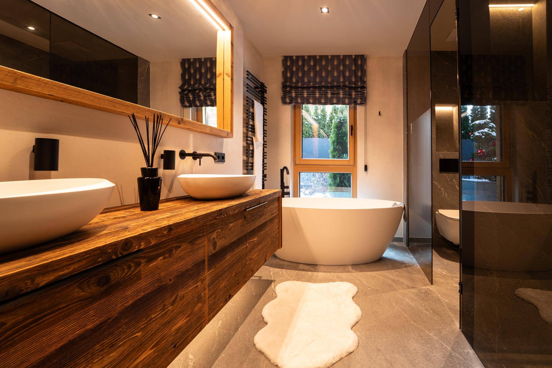 Modernes Badezimmer mit freistehender Badewanne, Doppelwaschbecken und Holzwaschtisch.