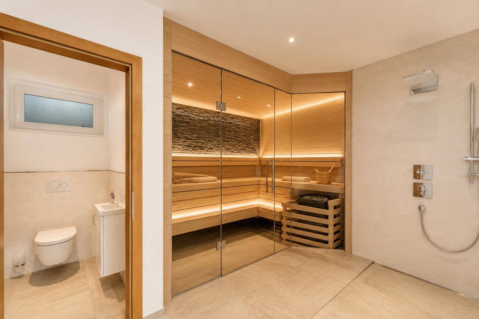 Exklusiver Wellnessbereich mit moderner Sauna, Dusche und separatem WC.