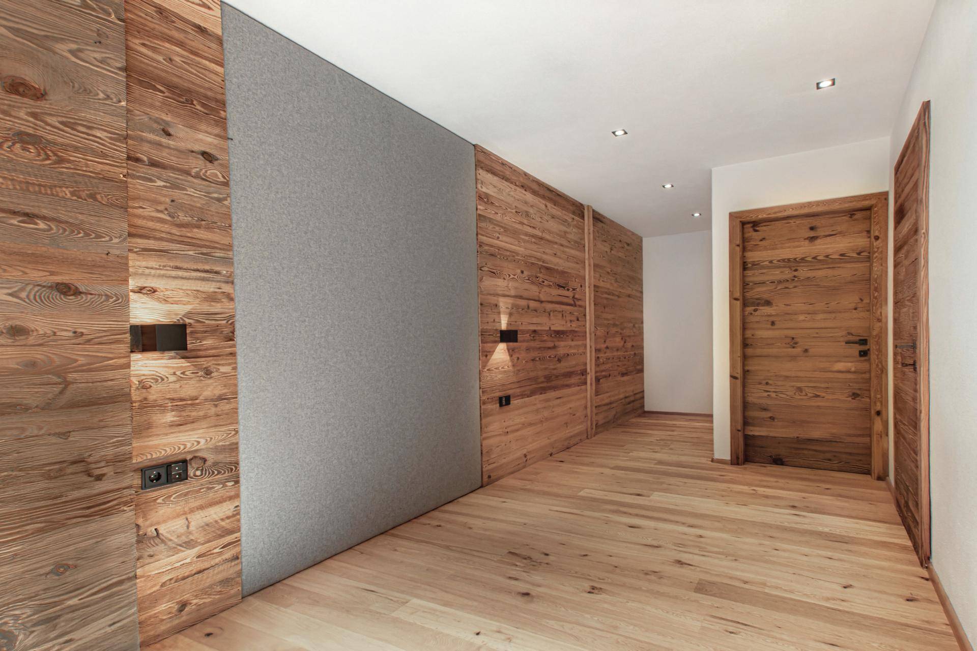 Heller Flur mit Holzwänden und modernem Design, der zu weiteren Räumen führt.