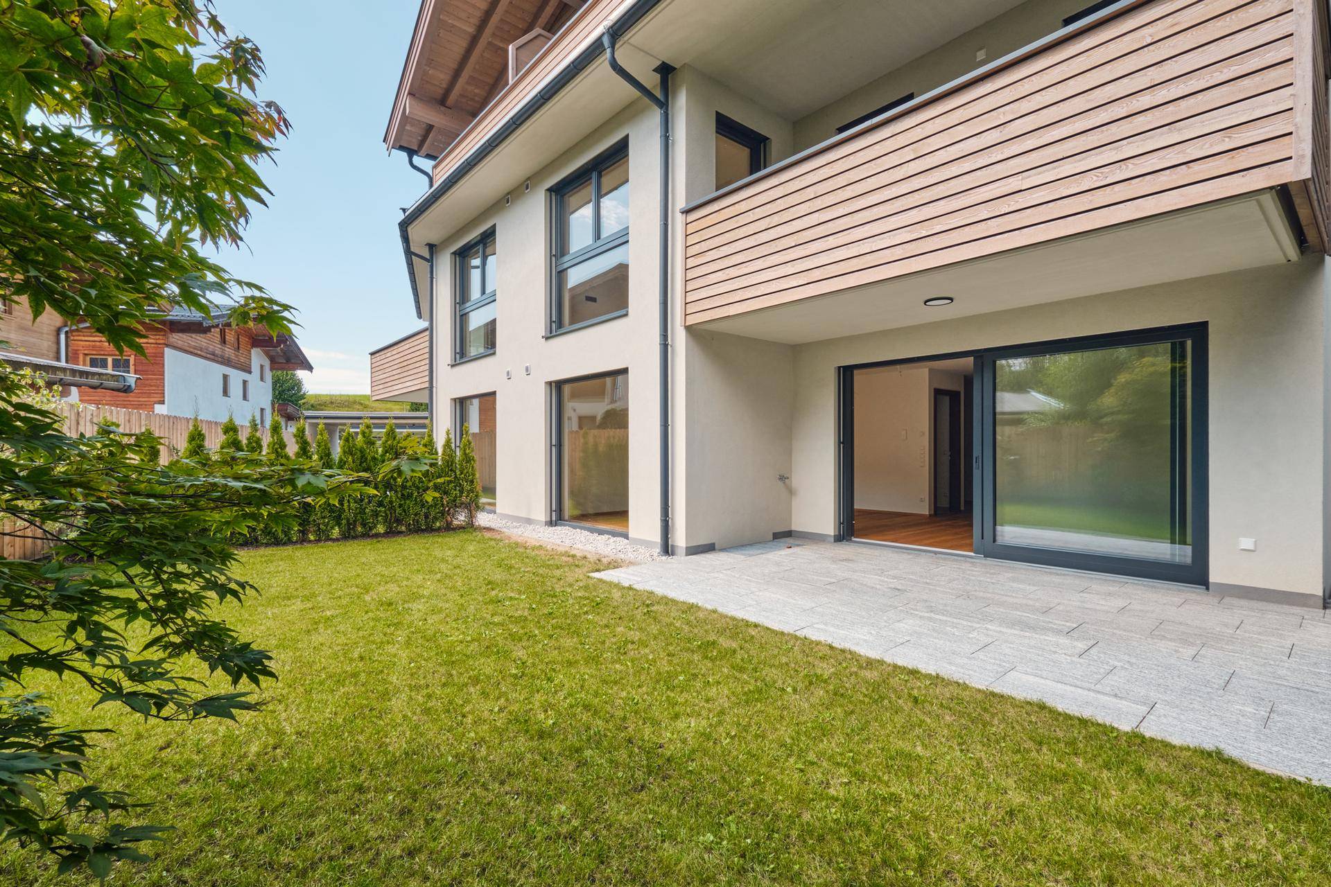 Gepflegter Garten mit Rasenfläche und Terrasse mit Zugang zu den Wohnräumen.