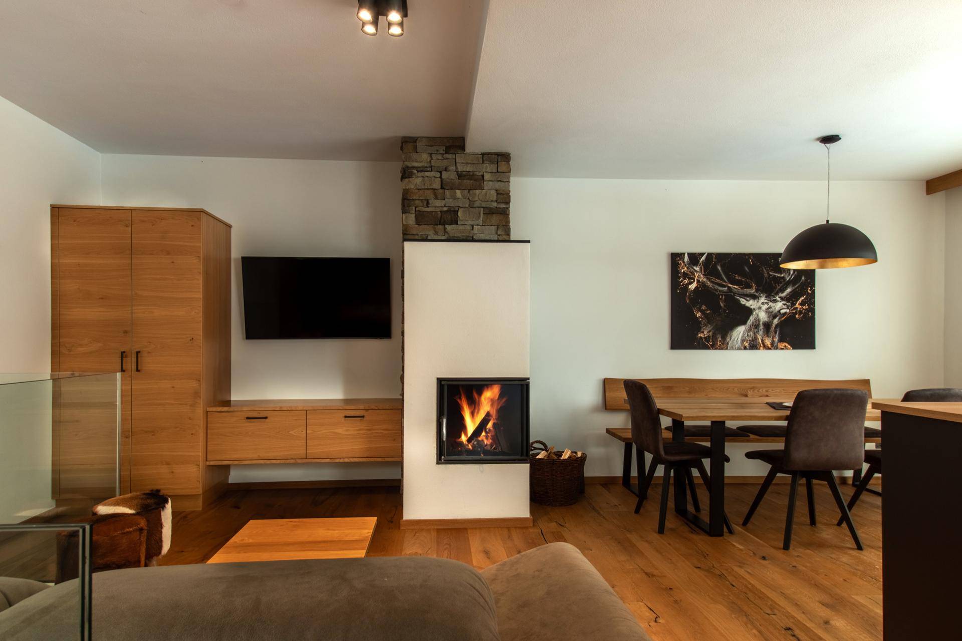 Heller Wohnbereich mit Kamin, Holzboden und moderner Einrichtung.