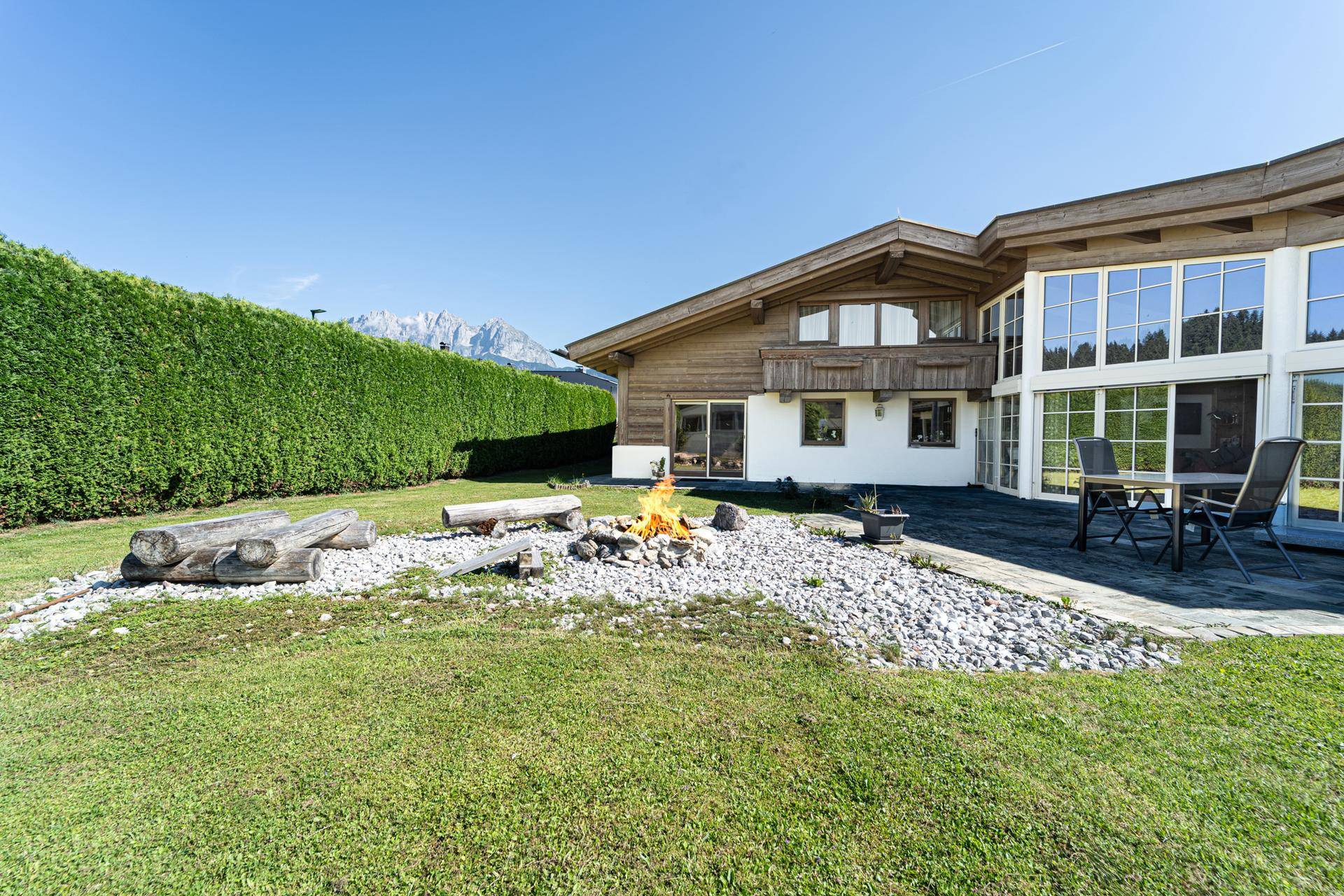 Großer Garten mit Rasenfläche, Feuerstelle und Sitzgelegenheiten, ideal für entspannte Abende im Freien.
