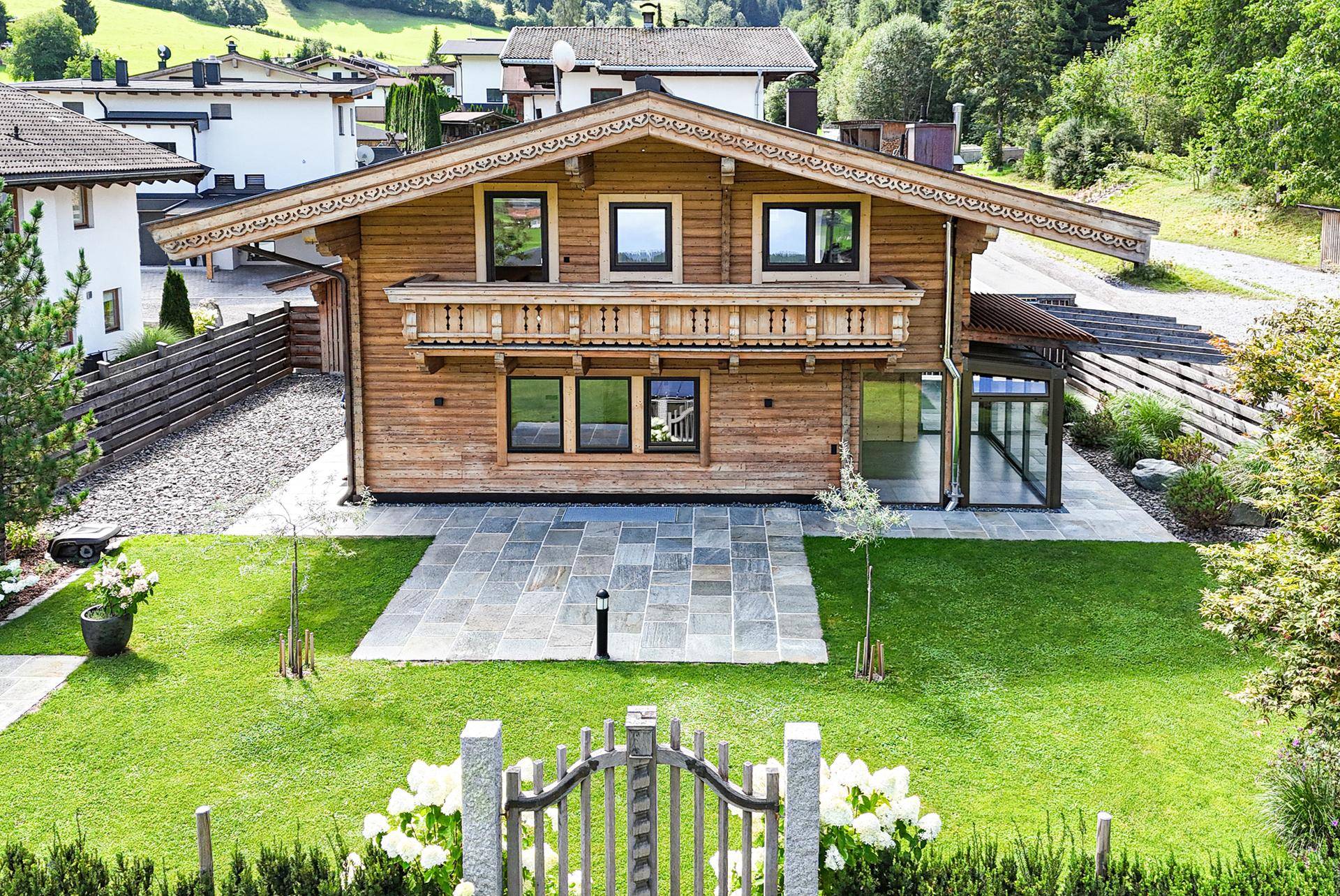 Charmantes Holzhaus im alpinen Stil mit gepflegtem Garten, Terrasse und Bergblick.