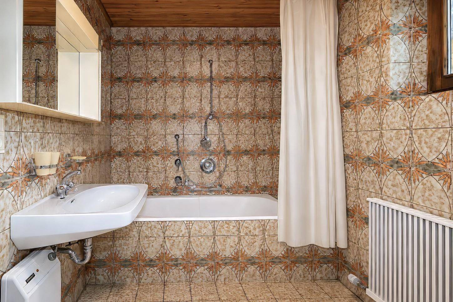 Badezimmer mit gemusterten Fliesen, Badewanne und Holzdecke im traditionellen Stil.