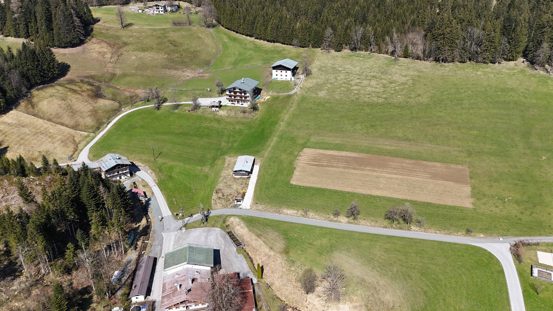 Weitläufige Luftaufnahme der ländlichen Gegend mit verstreuten Häusern und grünen Wiesen.