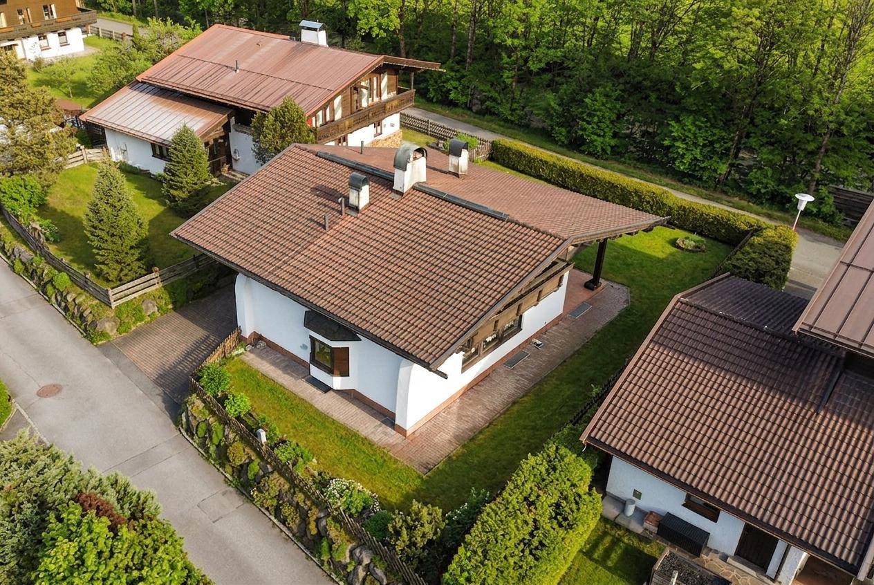 Luftaufnahme eines charmanten Hauses mit Satteldach und gepflegtem Garten in ländlicher Umgebung.