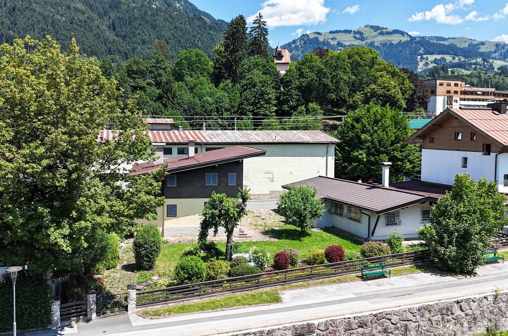 Haus in ländlicher Umgebung mit Blick auf bewaldete Hügel und traditionelle Architektur.