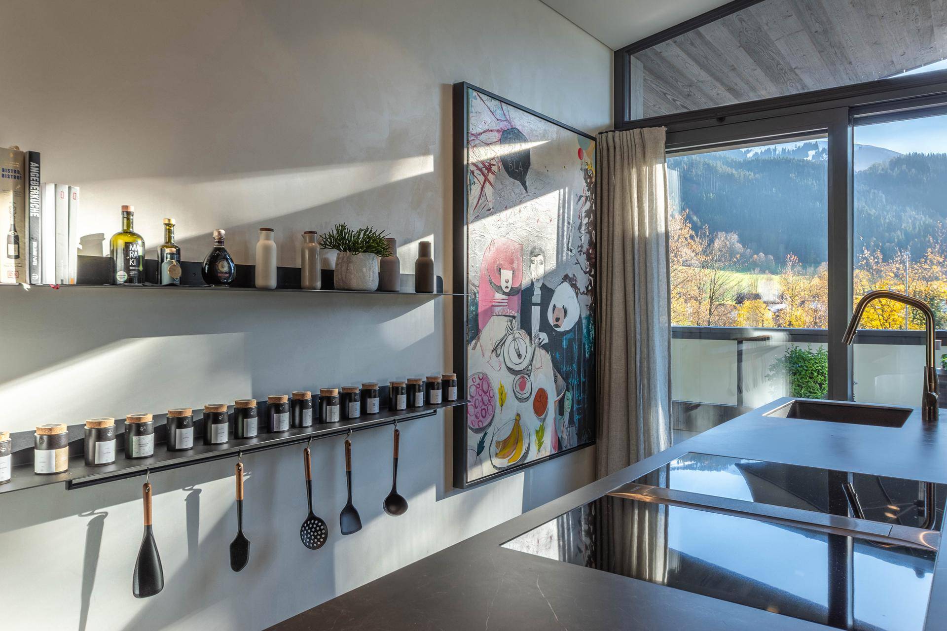 Moderne Küchenzeile mit Induktionskochfeld, eleganten Regalen und einem malerischen Ausblick.