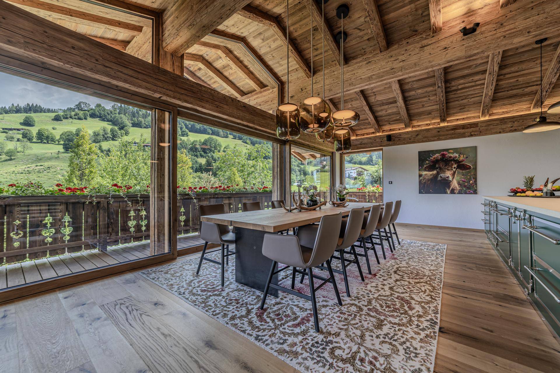 Heller Essbereich mit Holztisch, großen Fenstern und weitem Blick auf die grüne Landschaft.