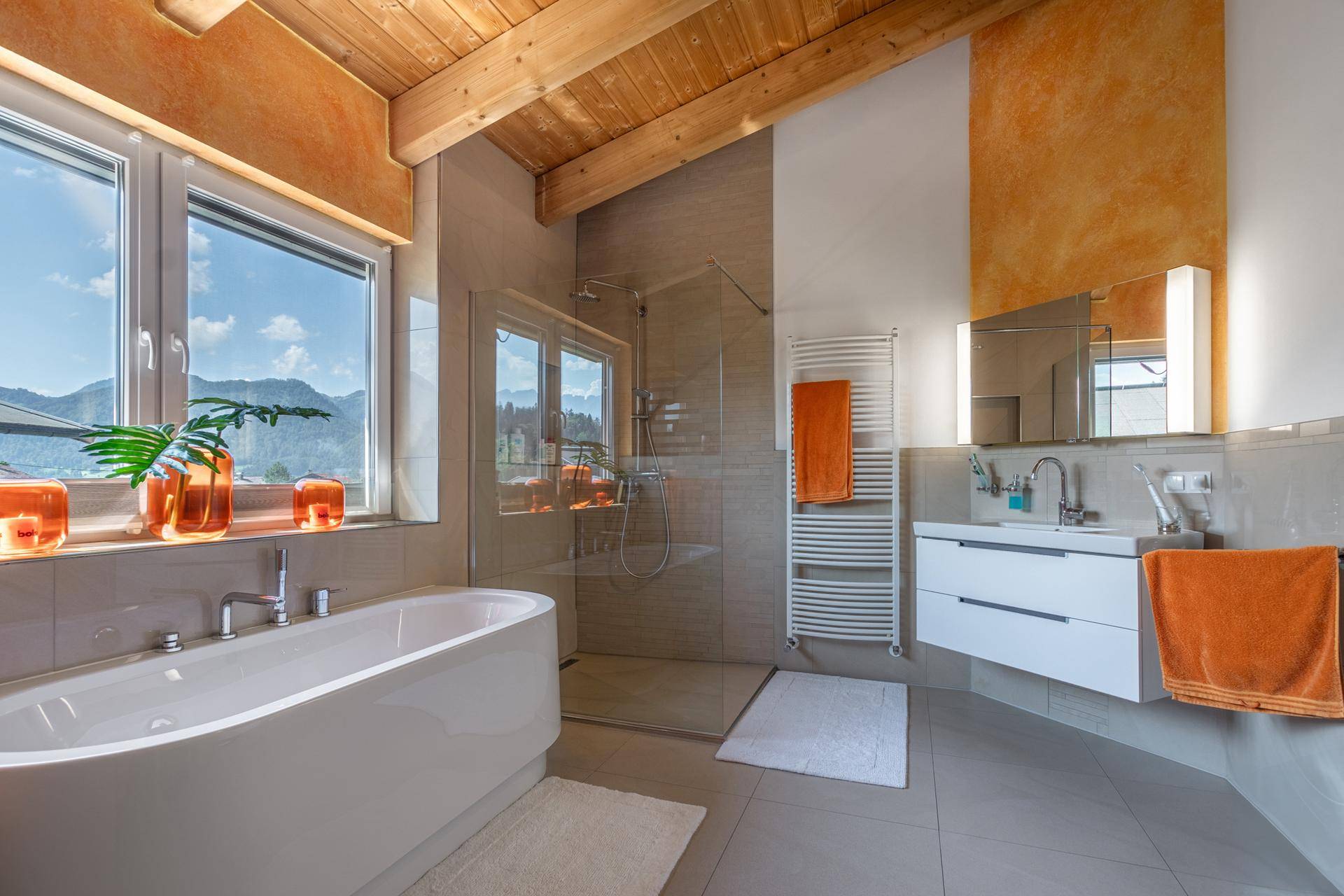 Modernes Badezimmer mit freistehender Badewanne, begehbarer Dusche und Bergblick.