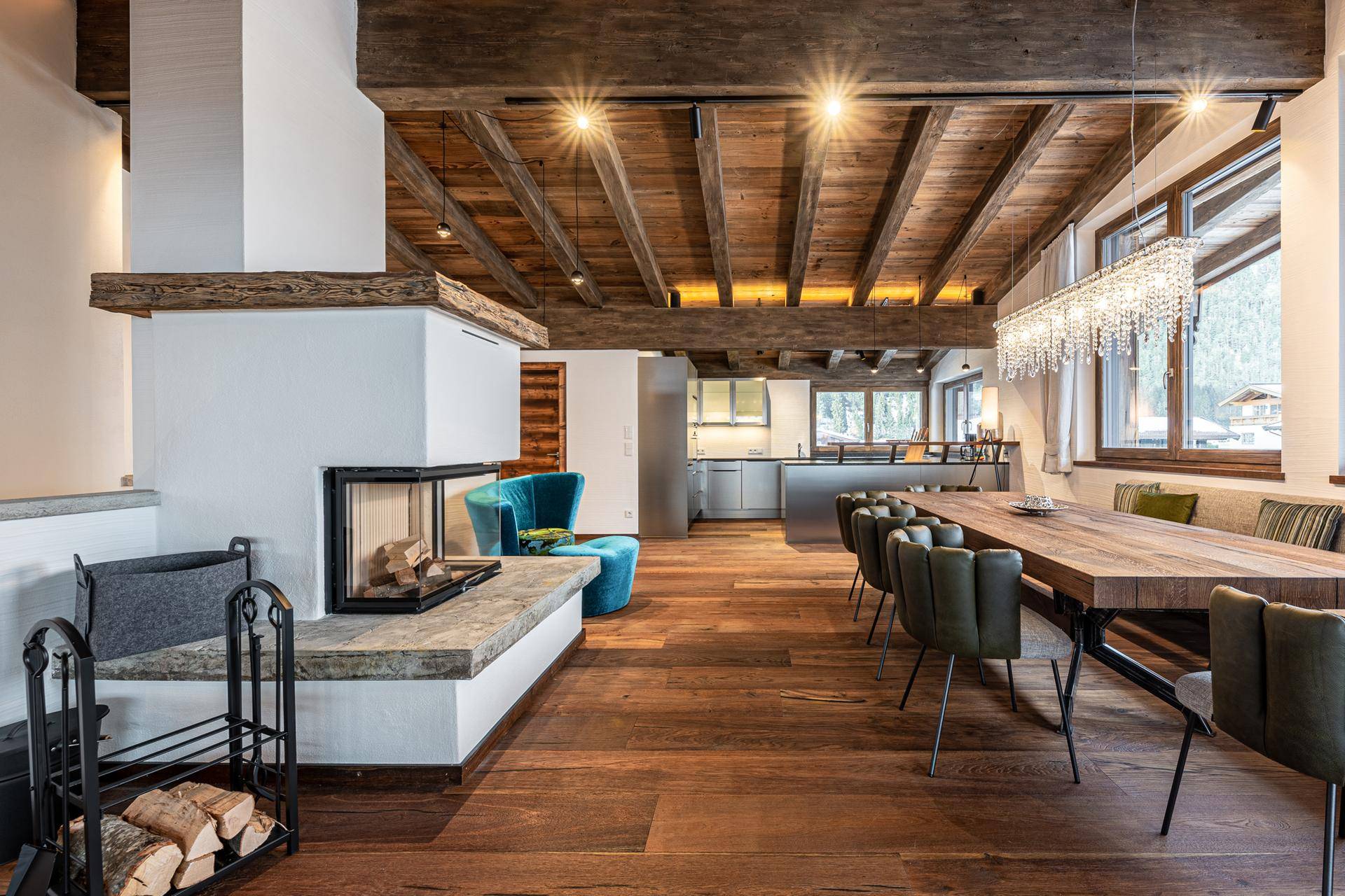 Gemütlicher Wohn-Essbereich mit Kamin, Holzboden und moderner Einrichtung.