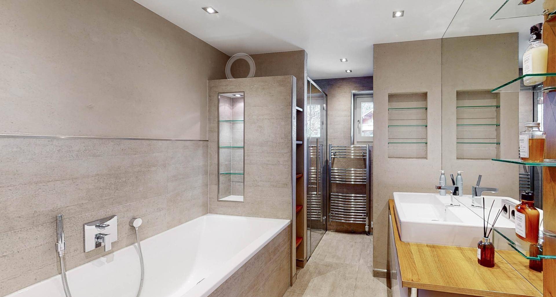 Modernes Badezimmer mit Badewanne, begehbarer Dusche und stilvollen Fliesen.