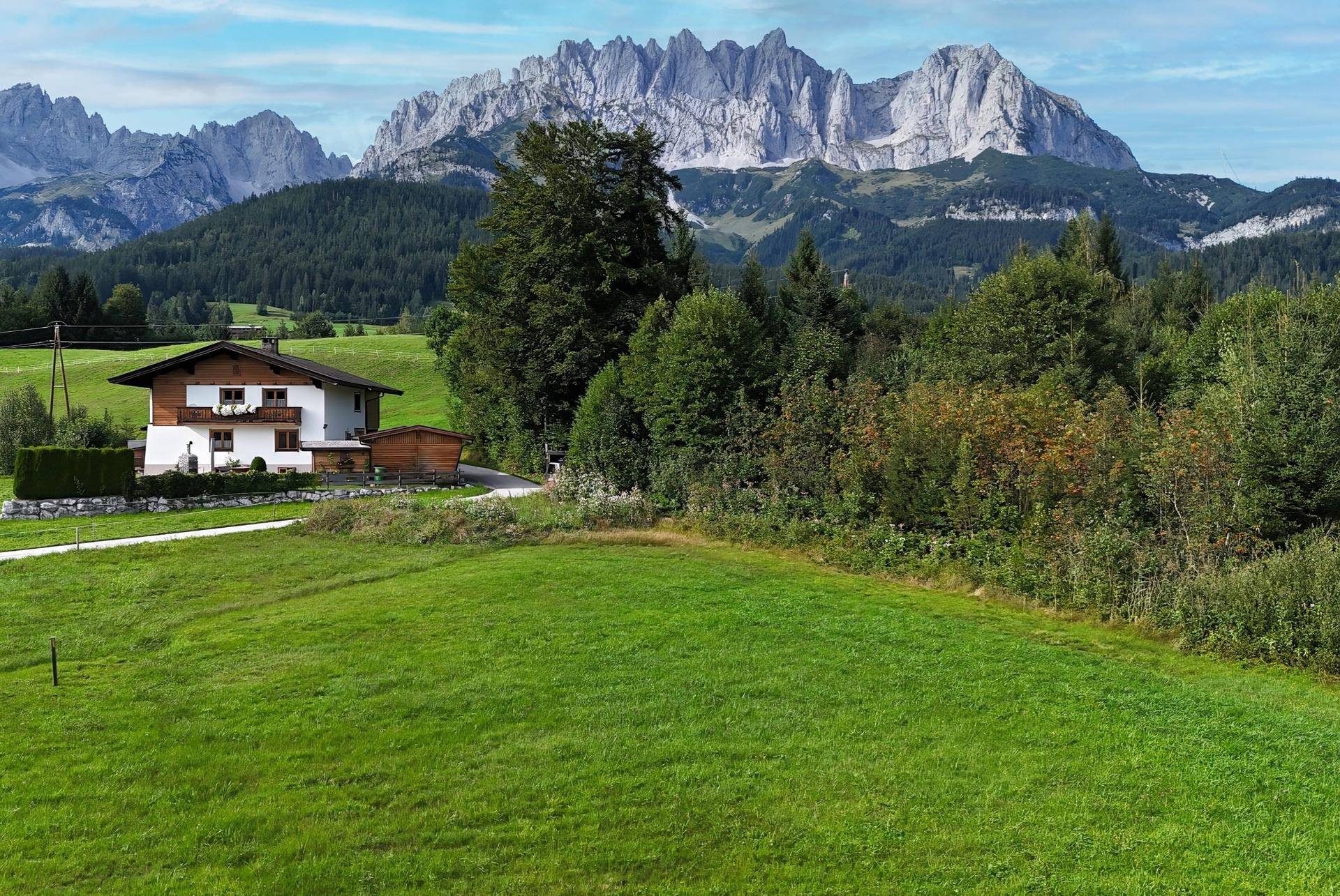 Haus in ländlicher Umgebung mit beeindruckendem Bergblick und weitläufigen Grünflächen.
