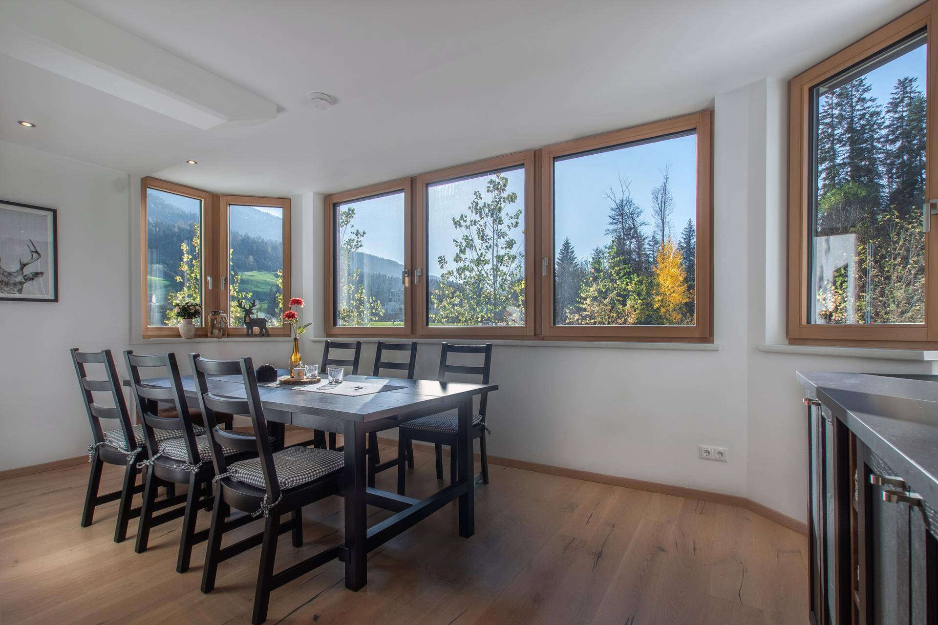 Geräumiger Essbereich mit großem Holztisch und weitem Blick auf die umliegende Berglandschaft.