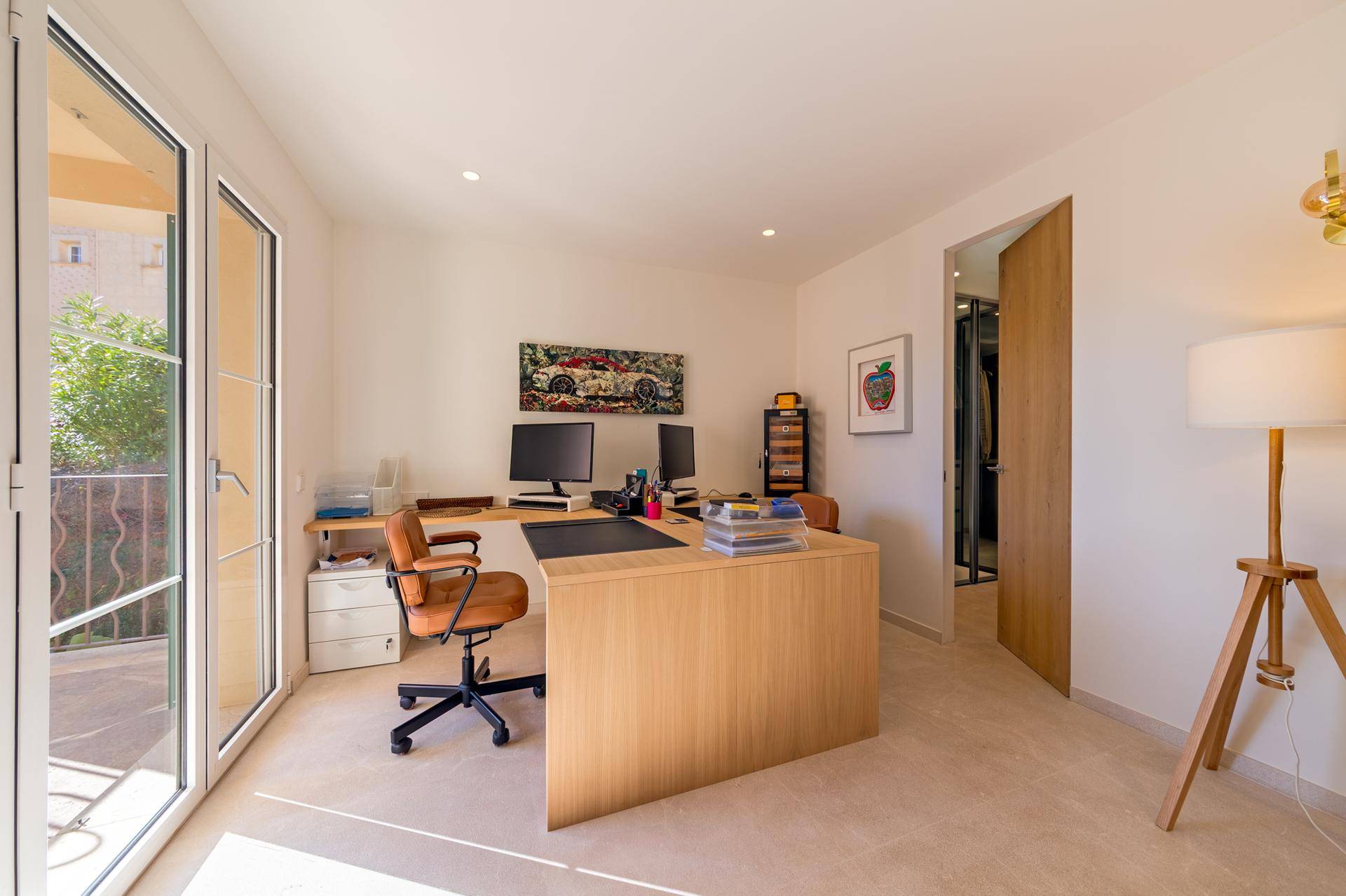 Helles Arbeitszimmer mit Holztisch, Bürostuhl und Zugang zu einem Außenbereich.