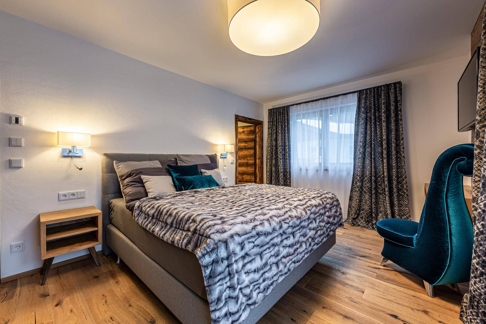 Komfortables Schlafzimmer mit Holzboden, Doppelbett und stilvoller Einrichtung.