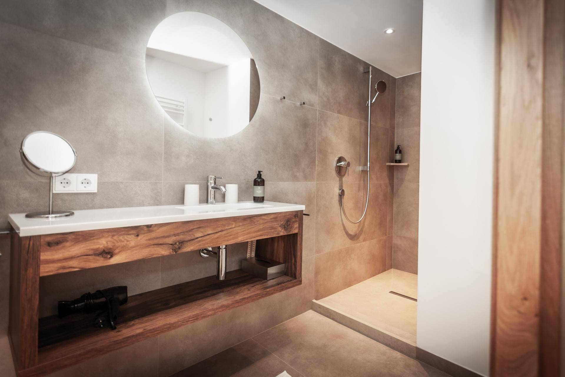 Modernes Badezimmer mit begehbarer Dusche, großformatigen Fliesen und Holzwaschtisch.
