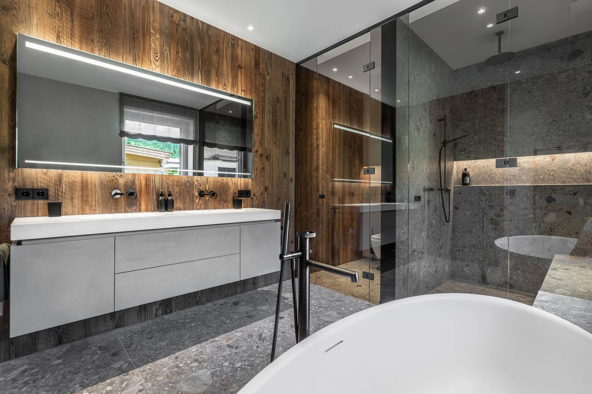 Luxuriöses Badezimmer mit freistehender Badewanne, großer begehbarer Dusche und Doppelwaschbecken.