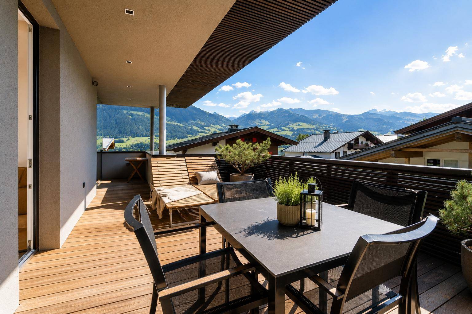 Geräumiger Balkon mit Holzboden, Sitzgelegenheiten und atemberaubendem Bergblick.