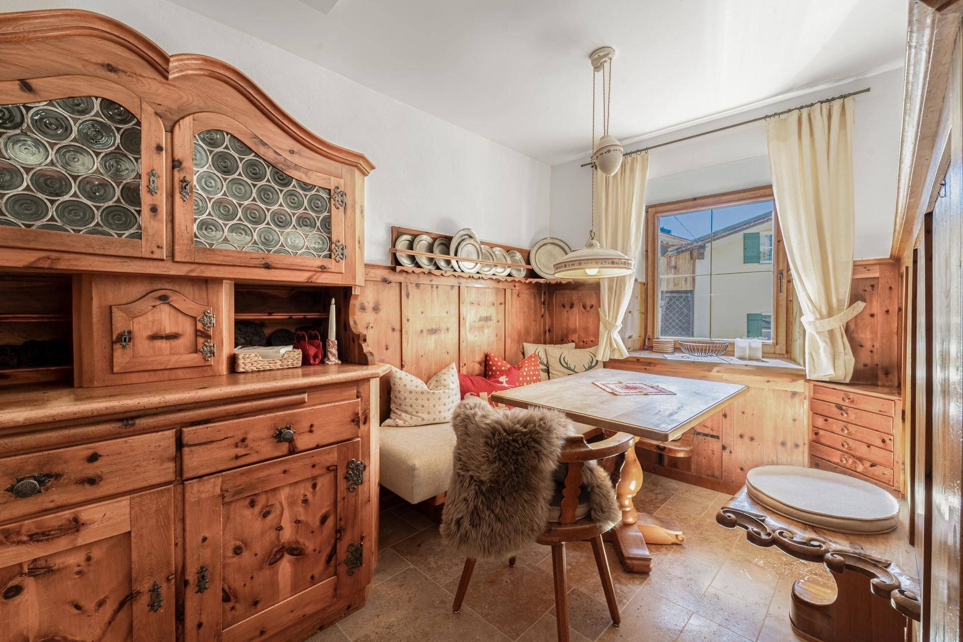 Traditioneller Essbereich im alpinen Stil mit Holztäfelung, rustikalen Möbeln und Fensterbank.