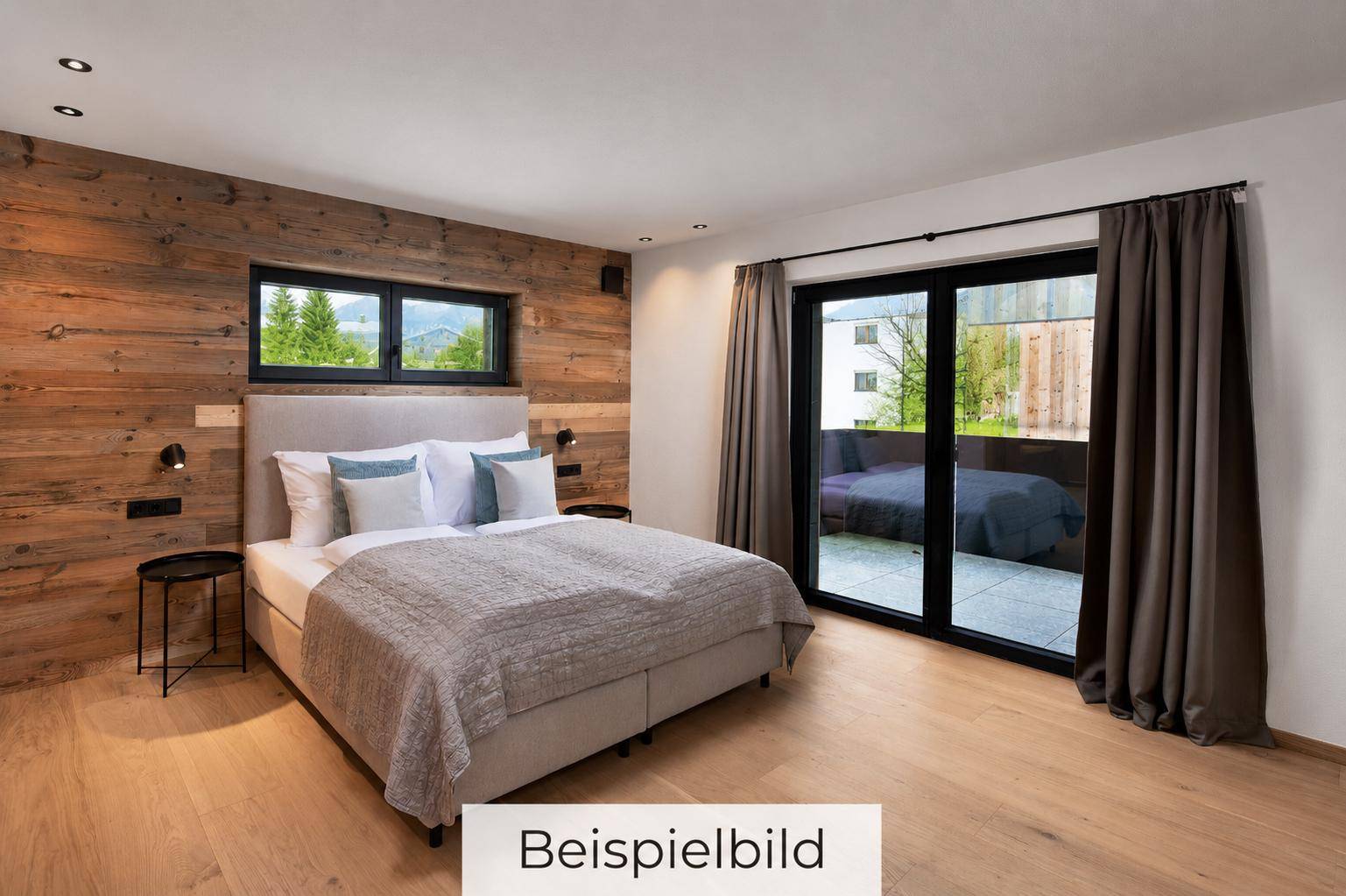 Gemütliches Schlafzimmer mit Holzwand, Balkonzugang und Blick ins Grüne.