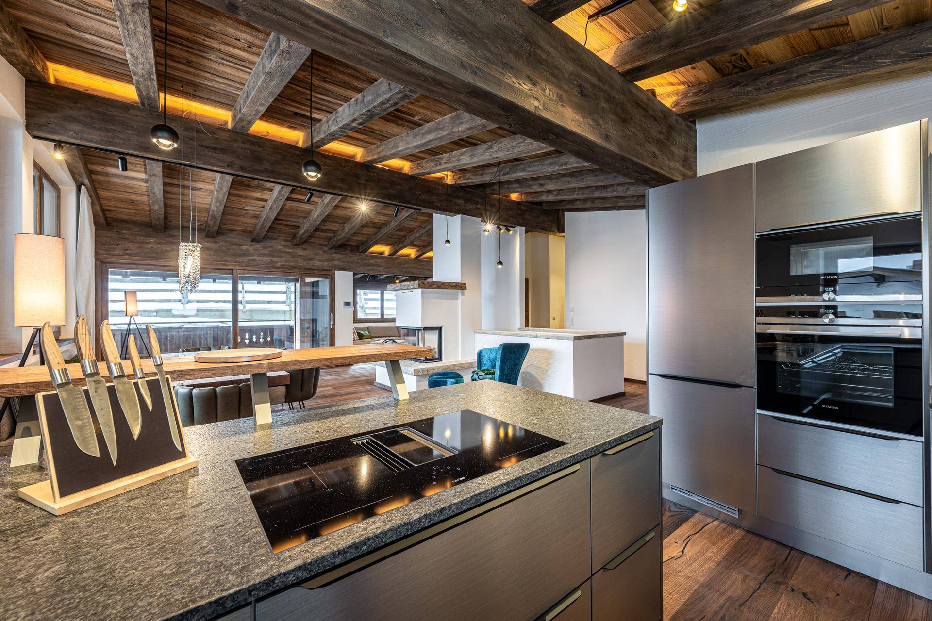 Moderne Küche mit Kochinsel, hochwertigen Geräten und offenem Blick in den Wohnbereich.