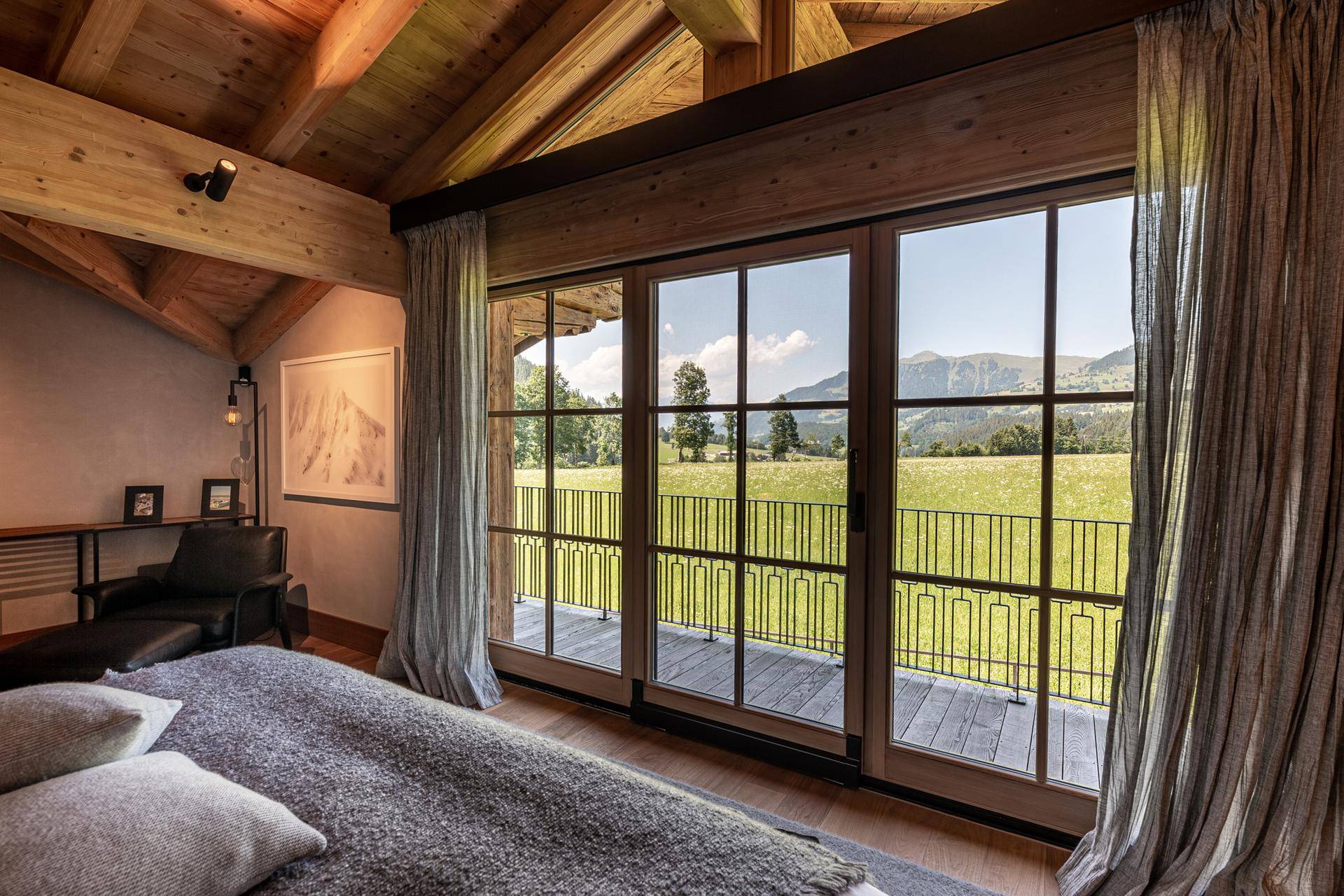 Schlafzimmer mit großen Fenstern, die einen weiten Blick auf die grüne Landschaft bieten.