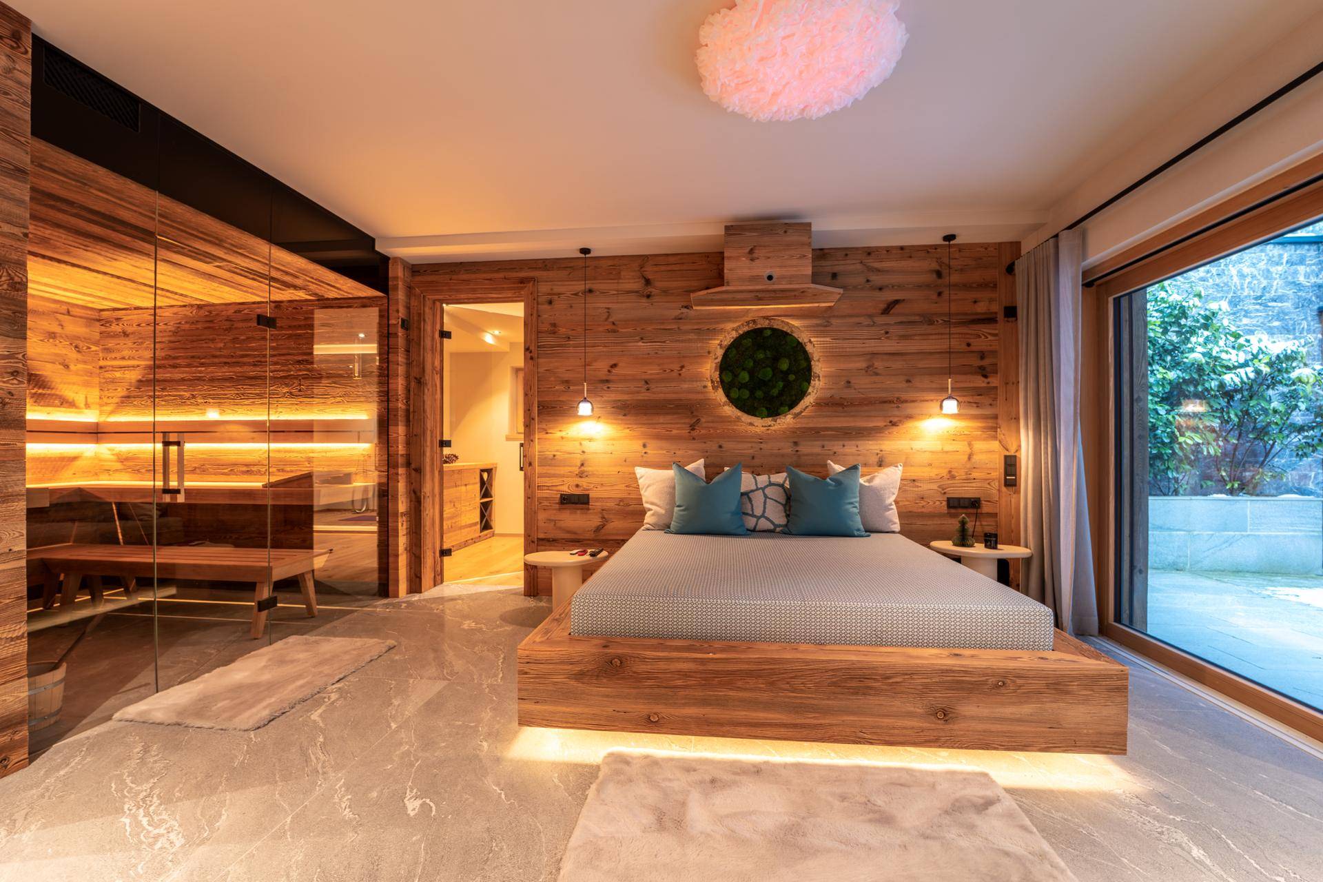 Luxuriöses Schlafzimmer mit Holzbett, indirekter Beleuchtung und integrierter Sauna.