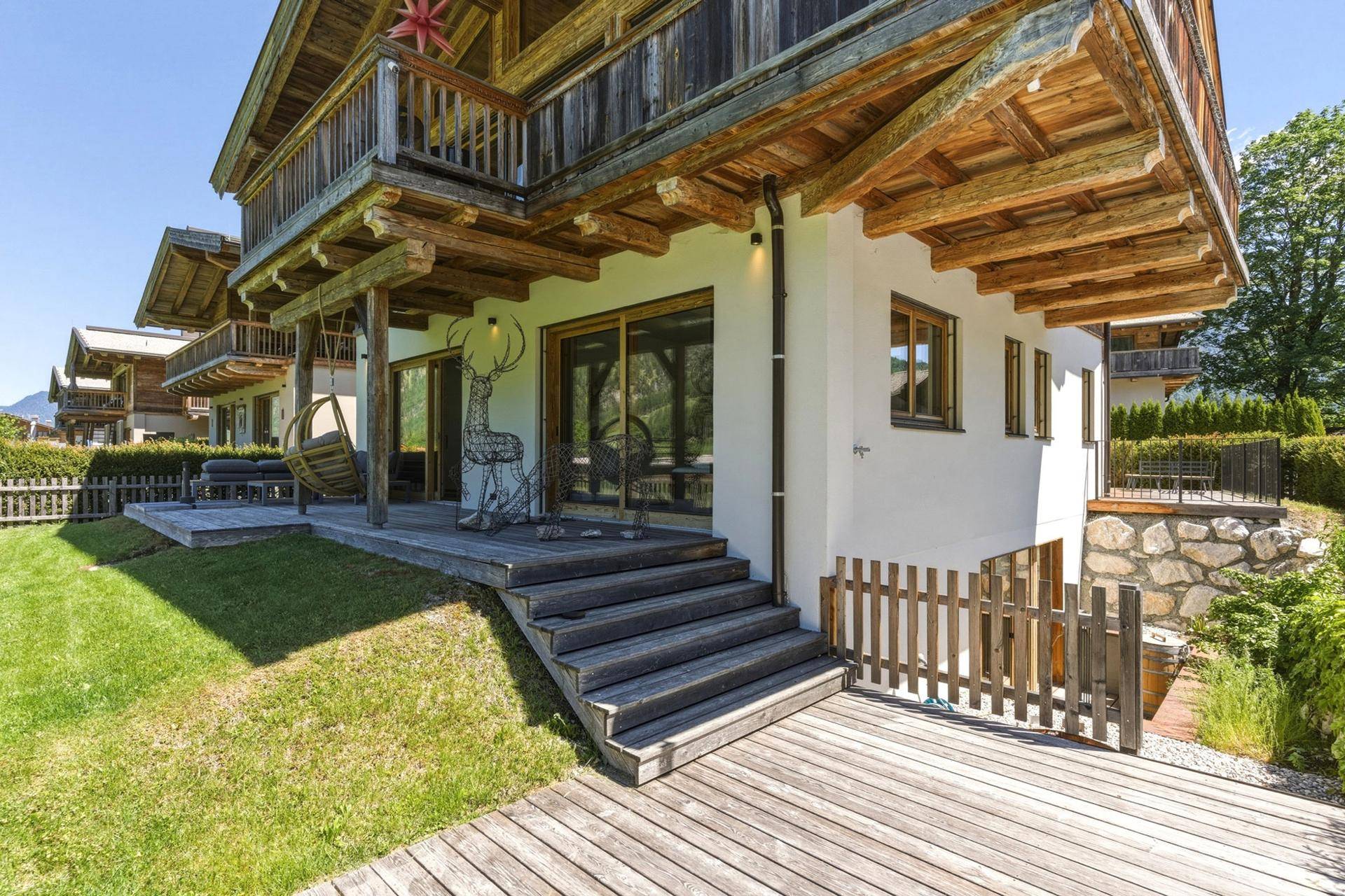 Gartenbereich mit Holzterrasse, Rasenfläche und direktem Zugang zum Haus.