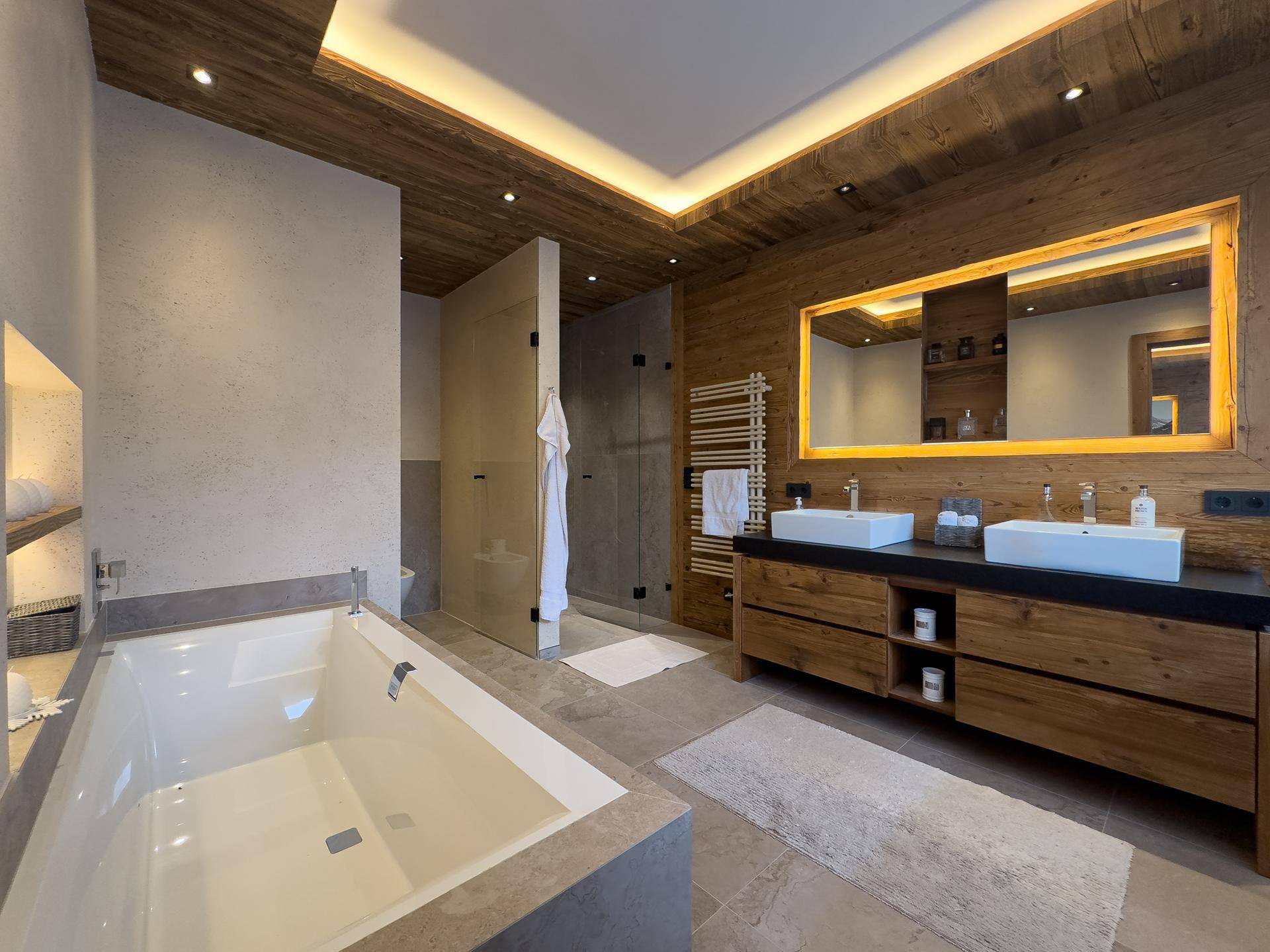 Luxuriöses Badezimmer mit Doppelwaschbecken, Badewanne und Holzakzenten im modernen Design.