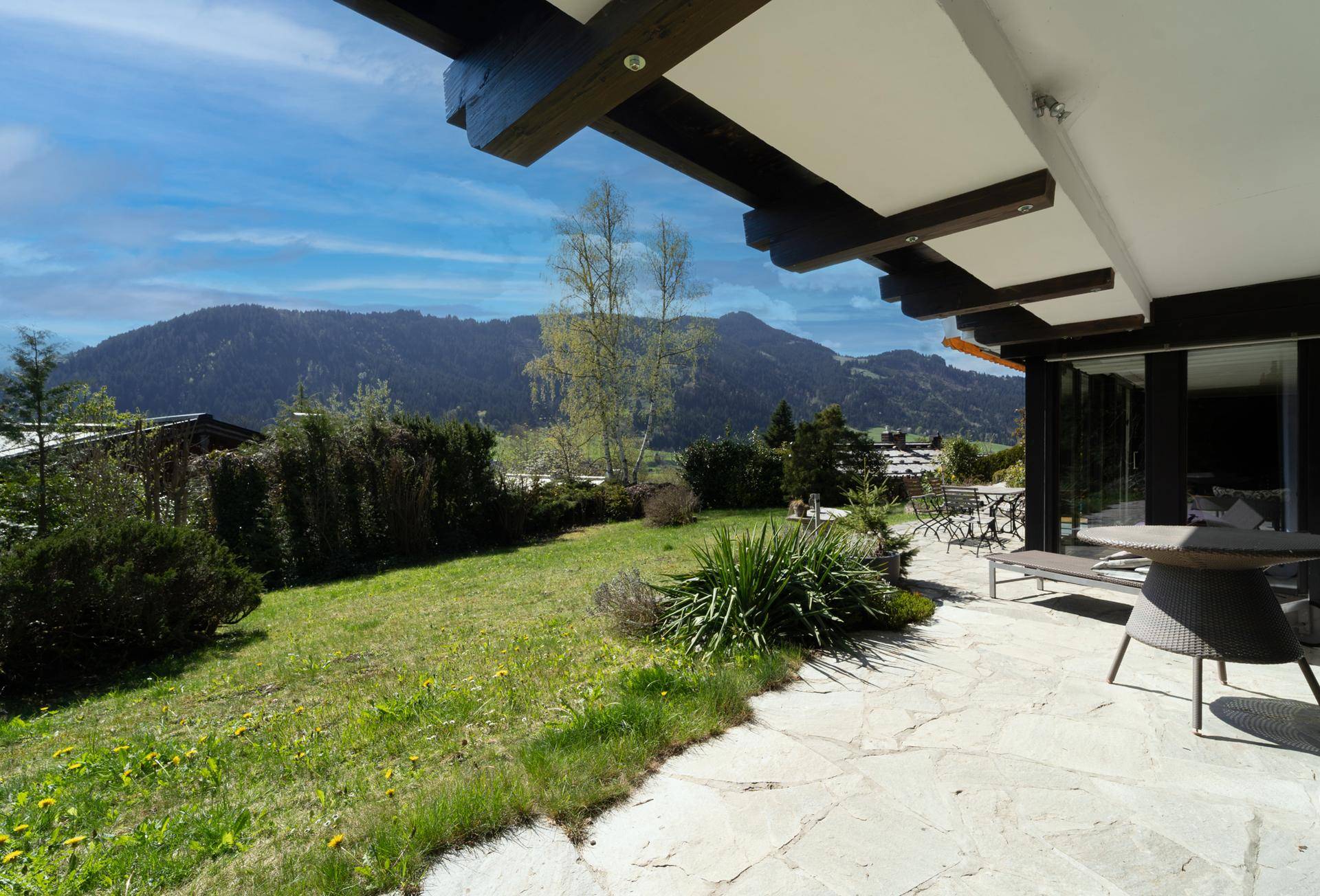 Geräumige Terrasse mit Sitzgelegenheiten und Panoramablick auf die Berge und das Tal.