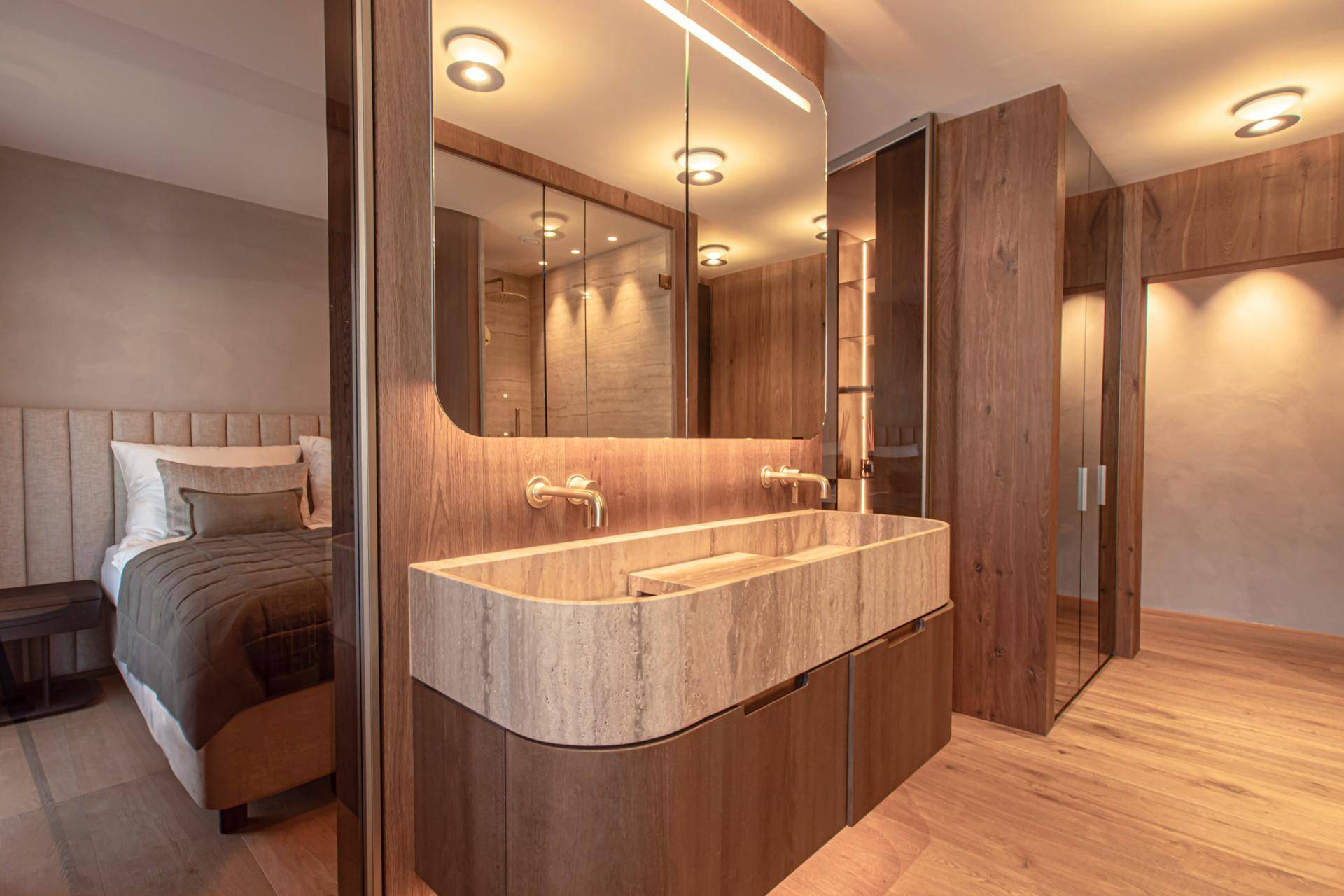 Schlafzimmer mit integriertem Waschtischbereich, Holzelementen und modernem Design.