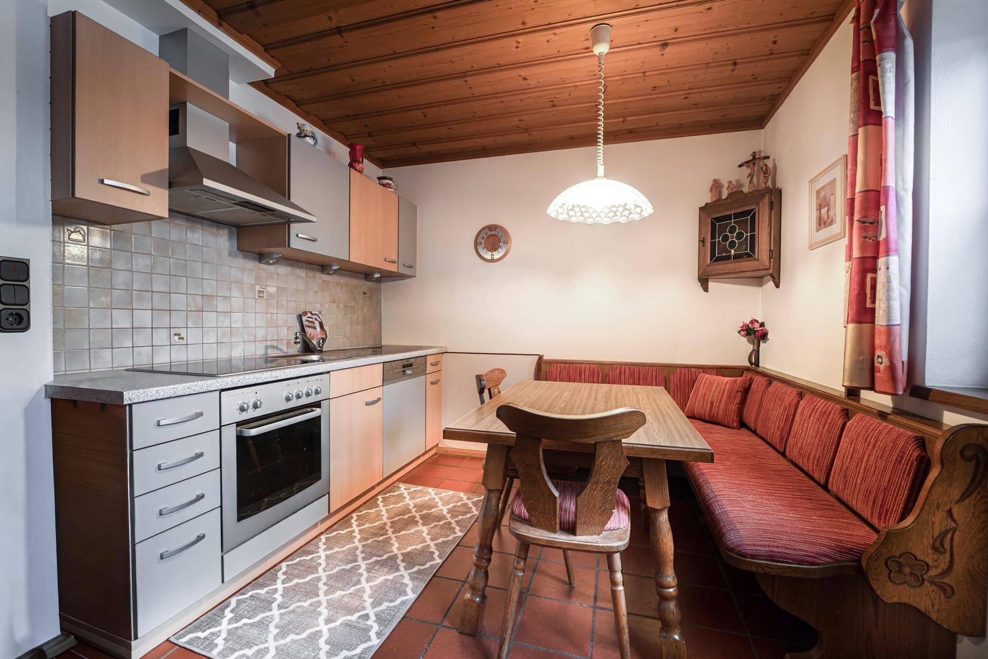 Funktionale Küche mit Essecke, Holzdecke und traditionellen Elementen.