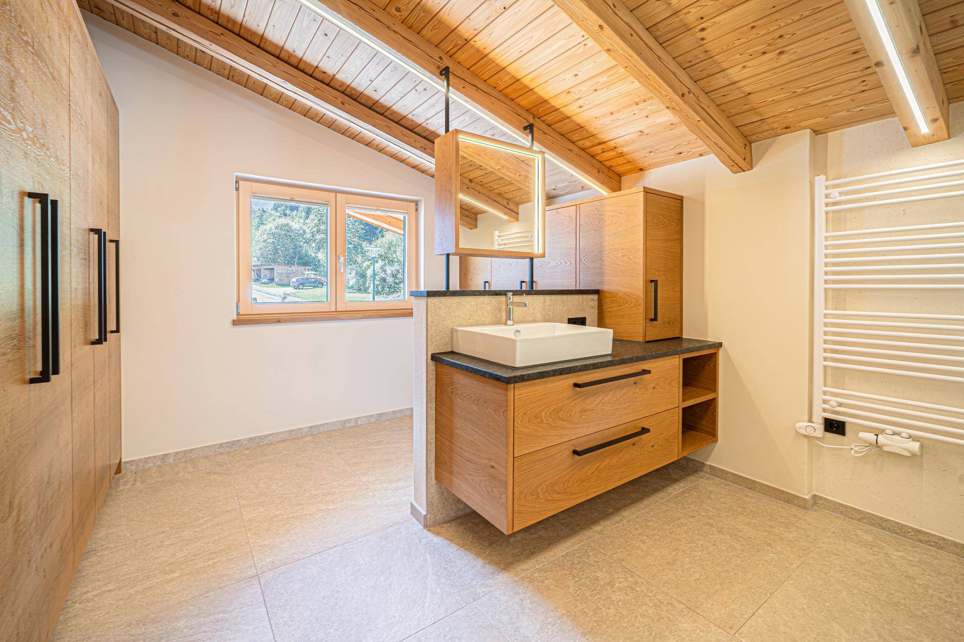 Modernes Badezimmer im Dachgeschoss mit Holzbalkendecke, Waschtisch und beheiztem Handtuchhalter.