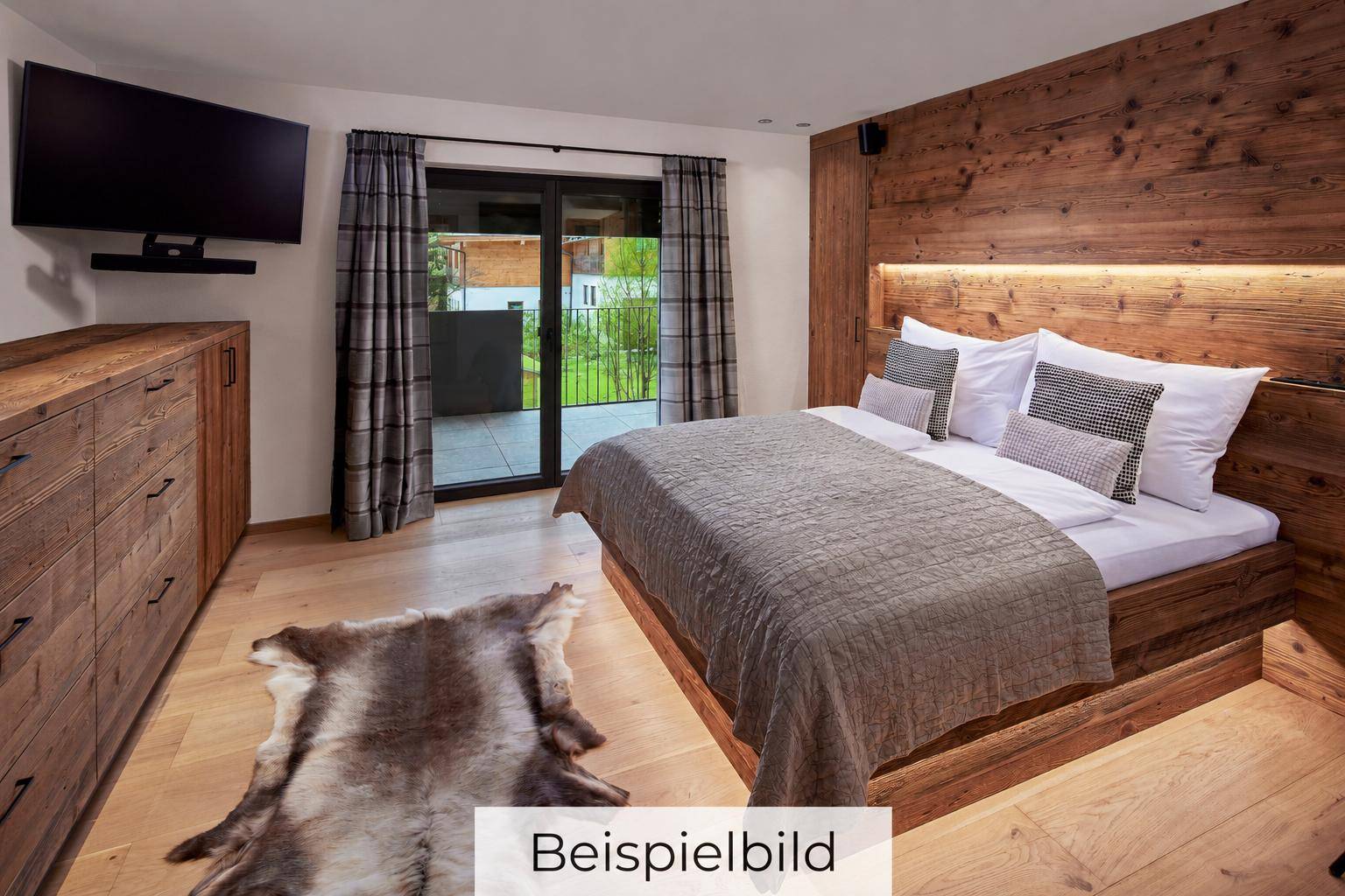 Gemütliches Schlafzimmer mit Holzwänden, großem Bett und direktem Zugang zu einem Balkon oder einer Terrasse.