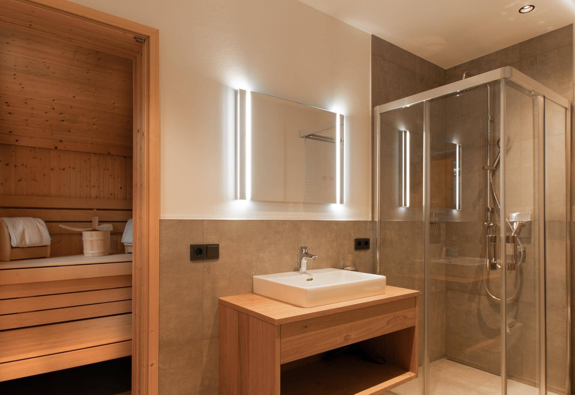 Elegantes Badezimmer mit Dusche, Einzelwaschbecken und integrierter Sauna.