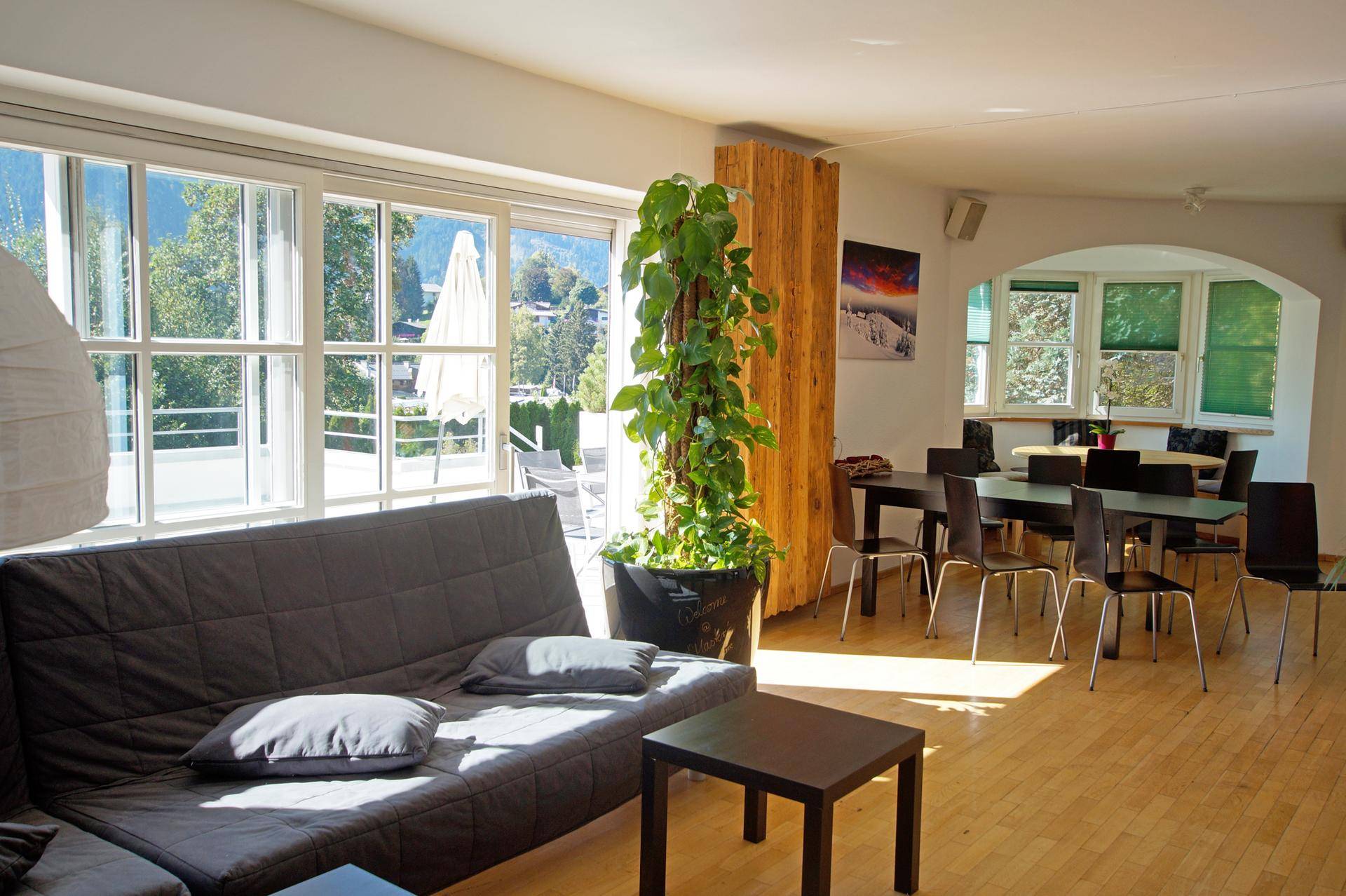 Lichtdurchfluteter Wohn- und Essbereich mit Zugang zu einer Terrasse und Blick auf die umliegende Natur.
