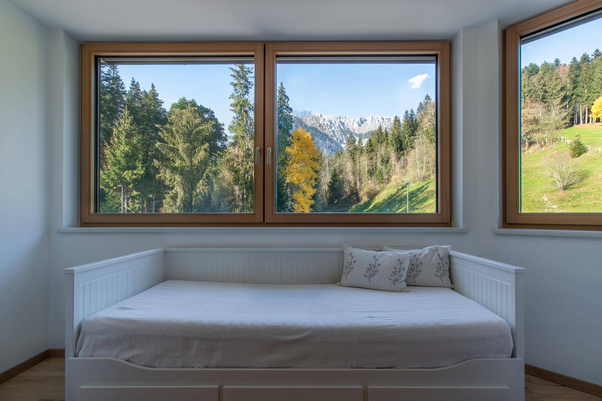 Gemütliches Tagesbett am Fenster mit beeindruckendem Blick auf die Berge und Wälder.